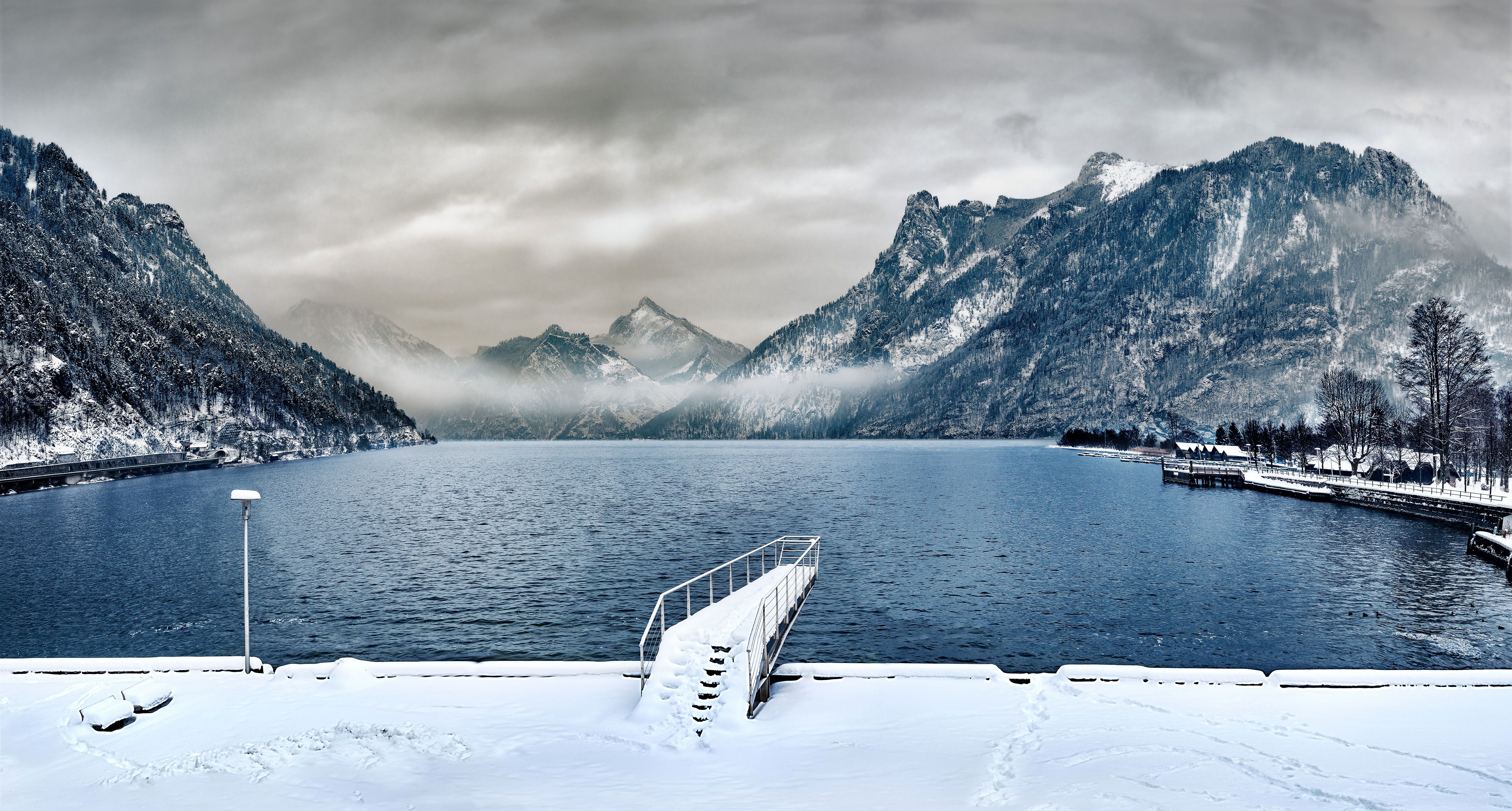 Snowy Mountains Overlooking a Lake with a Pier HD Wallpaper