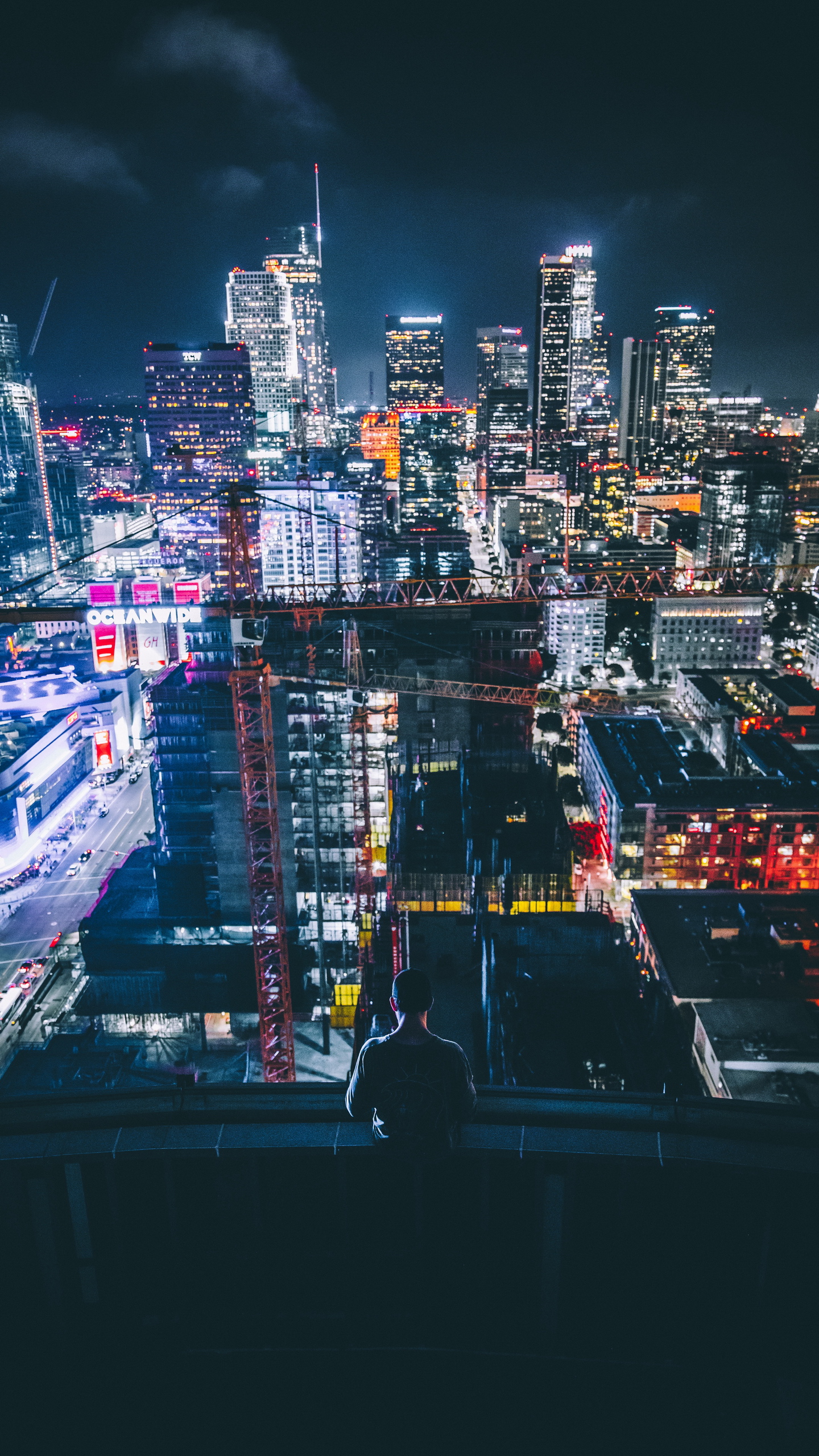 Person on rooftop overlooking city at night HD Wallpaper