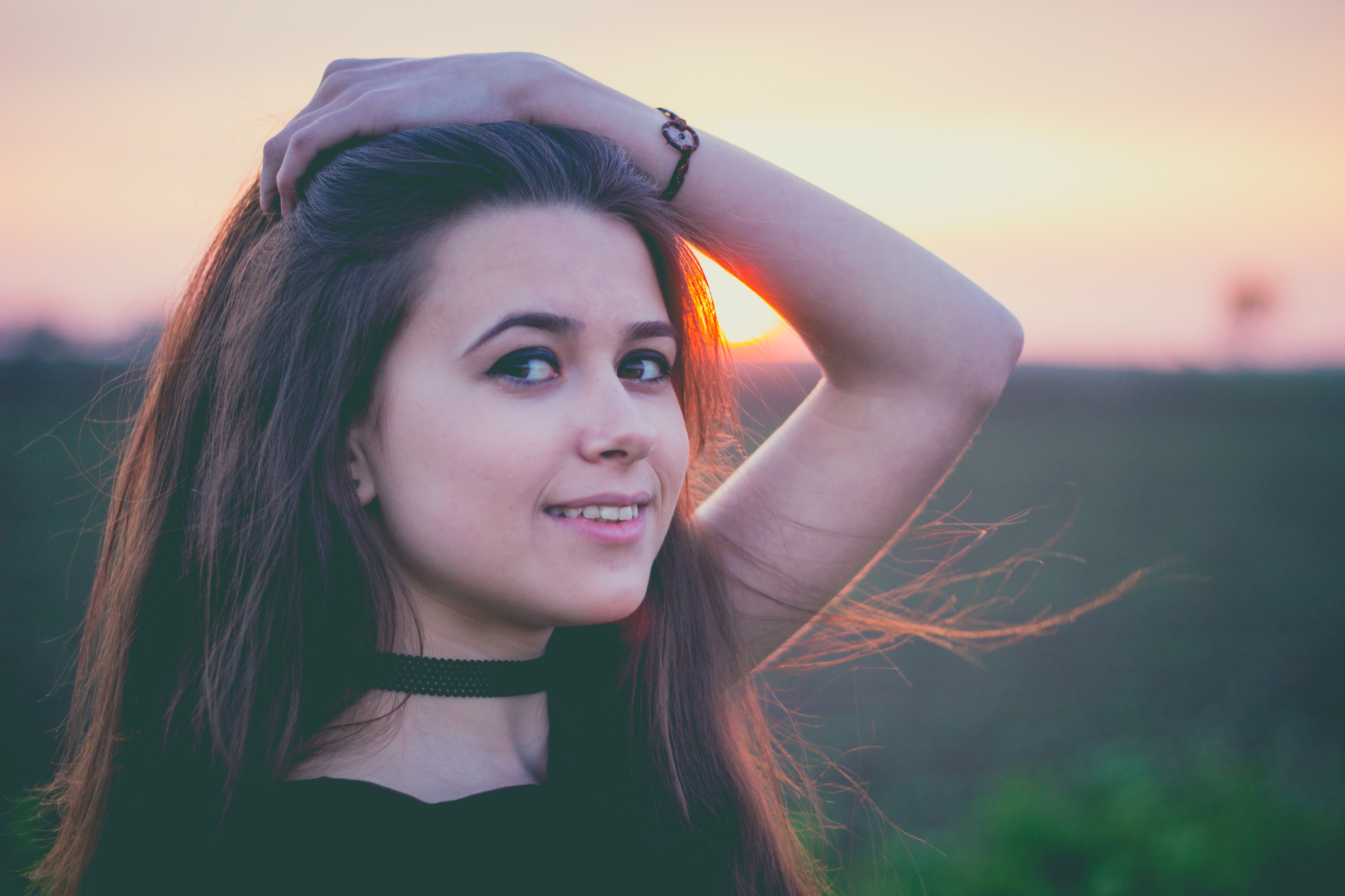 Woman with hand on head at sunset HD Wallpaper