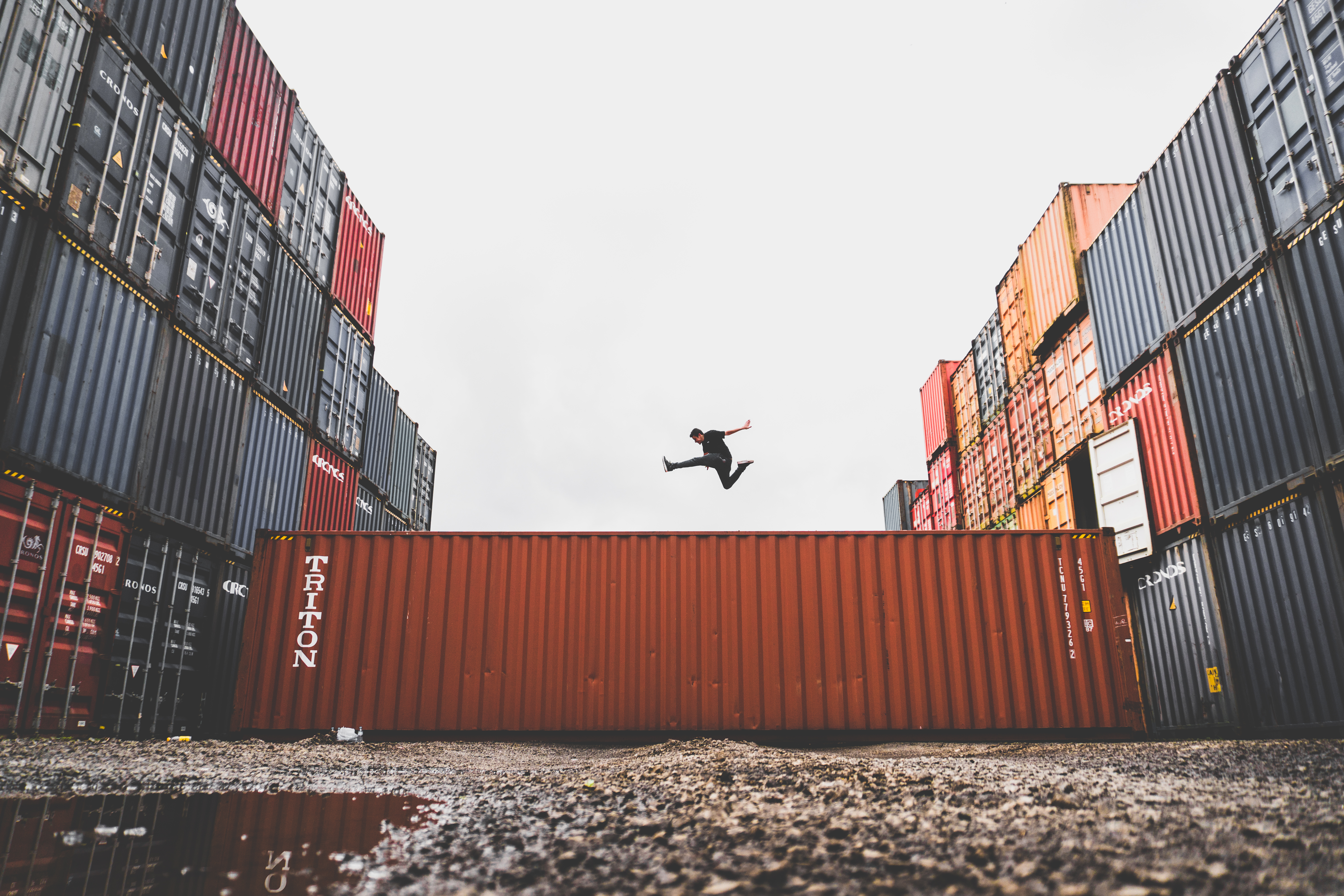 Man jumping over a shipping container HD Wallpaper