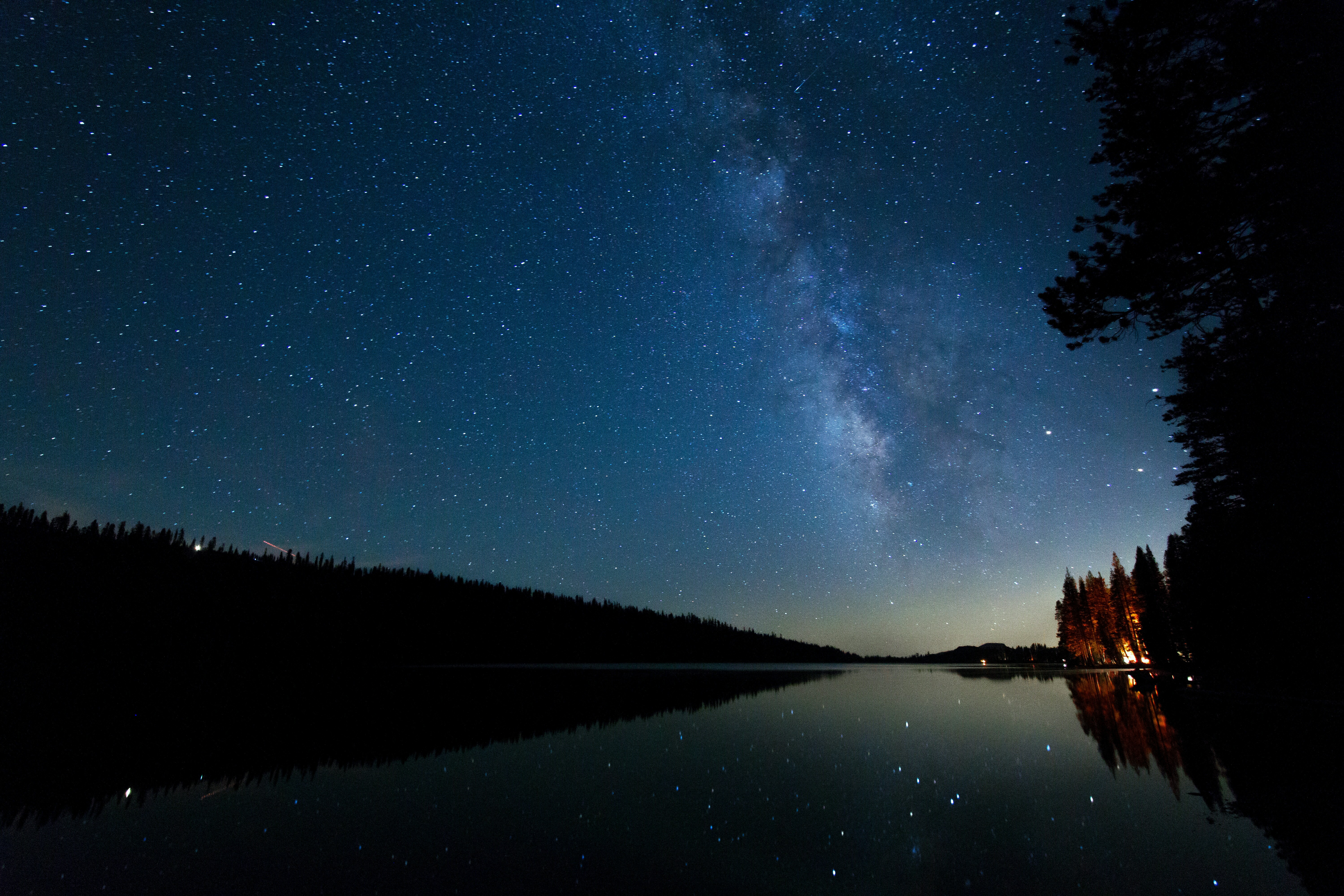 Milky Way over a dark lake and forest at night HD Wallpaper