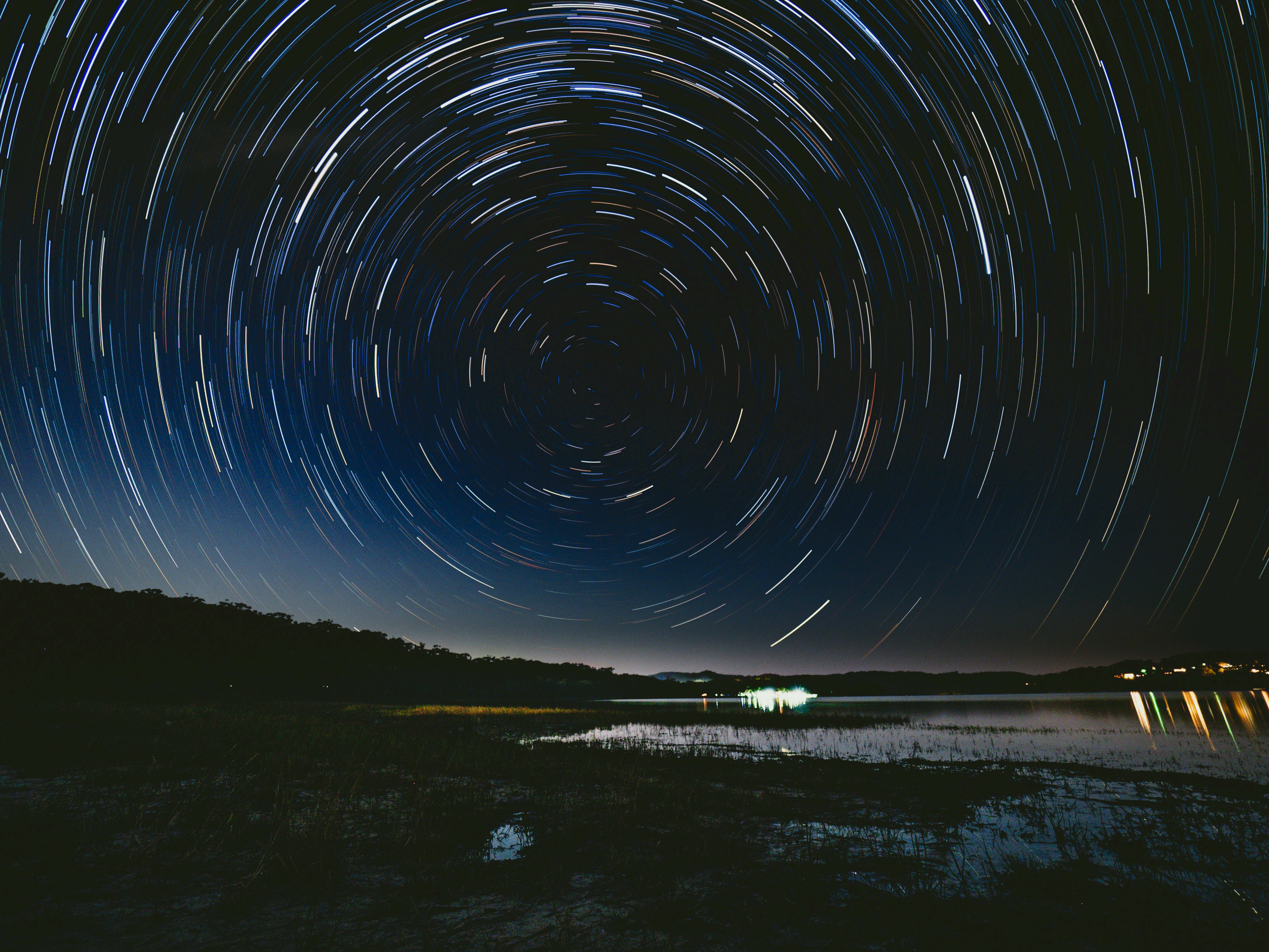 Star trails over a lake at night HD Wallpaper