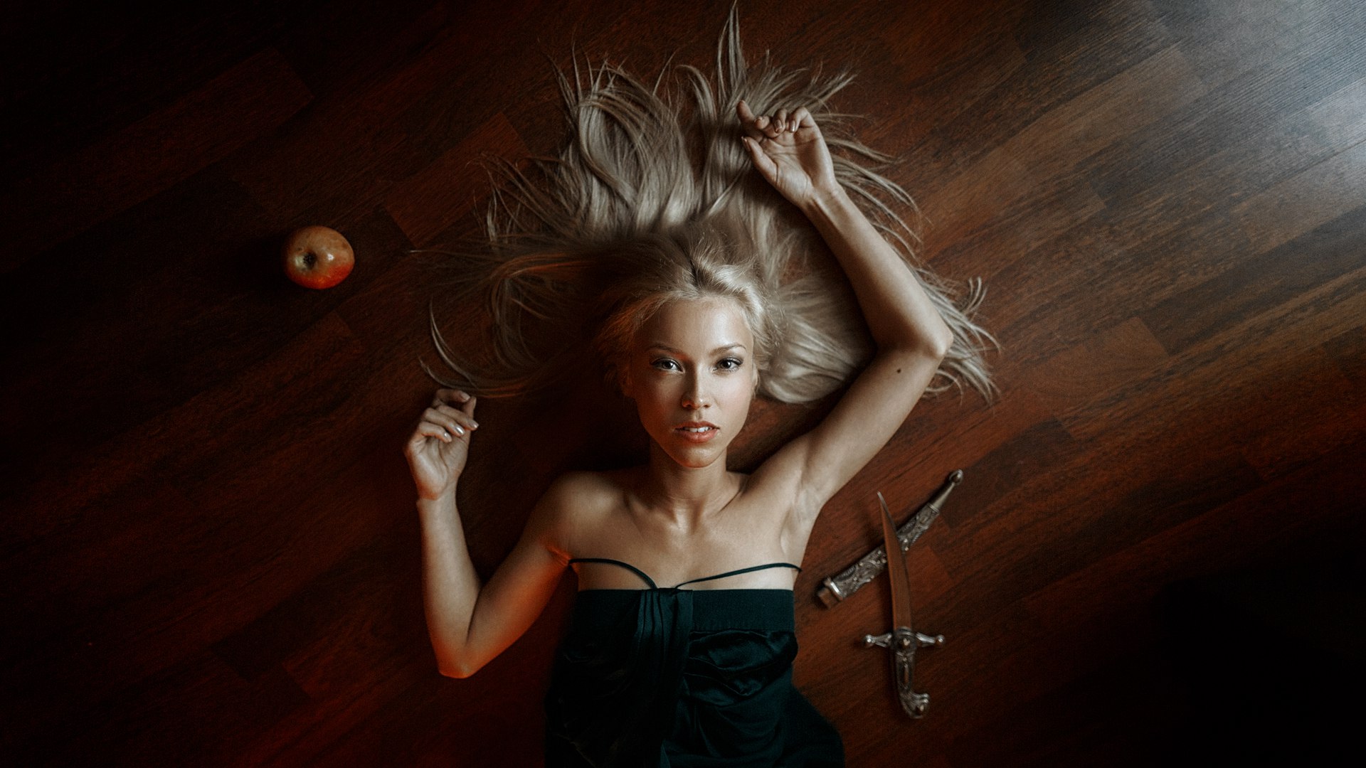 Woman with blonde hair lying on the floor with an apple and a dagger HD Wallpaper