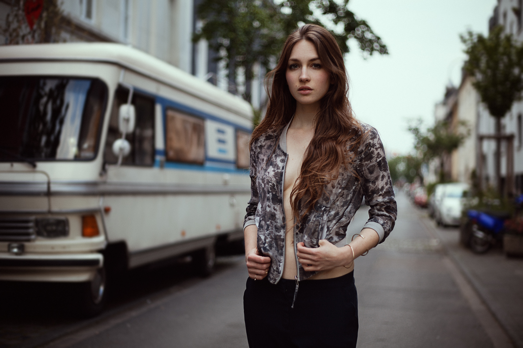 Woman in jacket standing on street with RV HD Wallpaper
