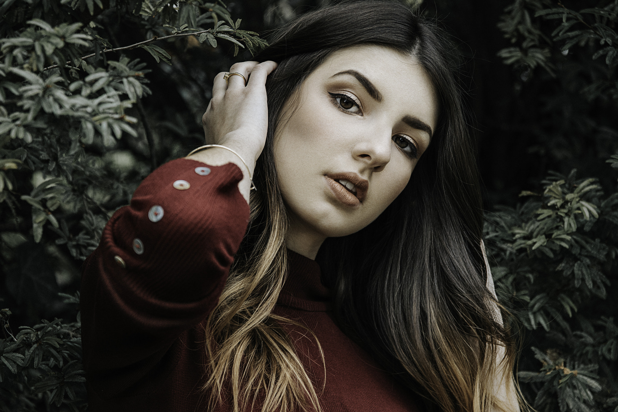 Woman with dark hair and makeup in a red sweater HD Wallpaper