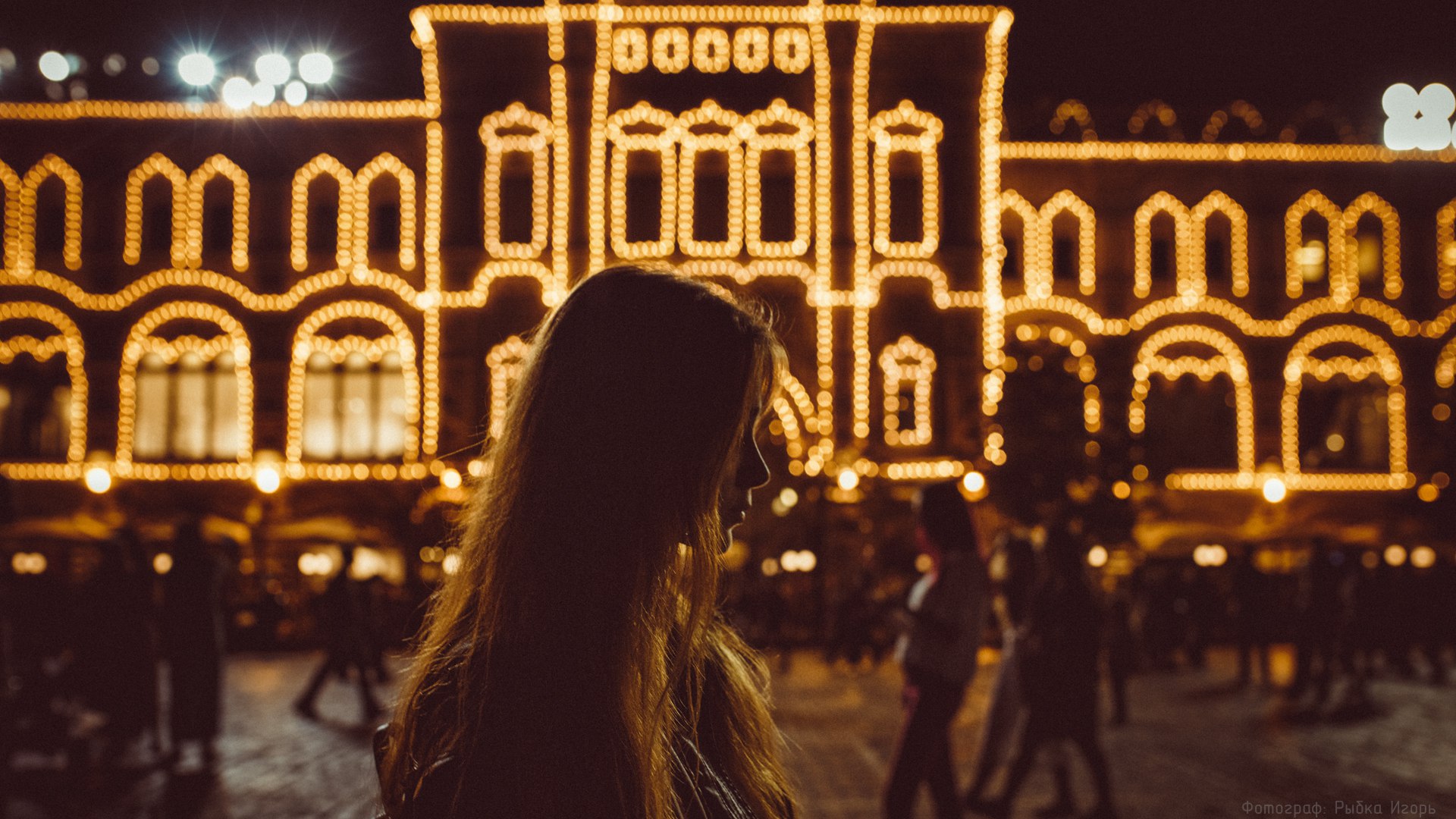 Woman in profile with illuminated building at night HD Wallpaper
