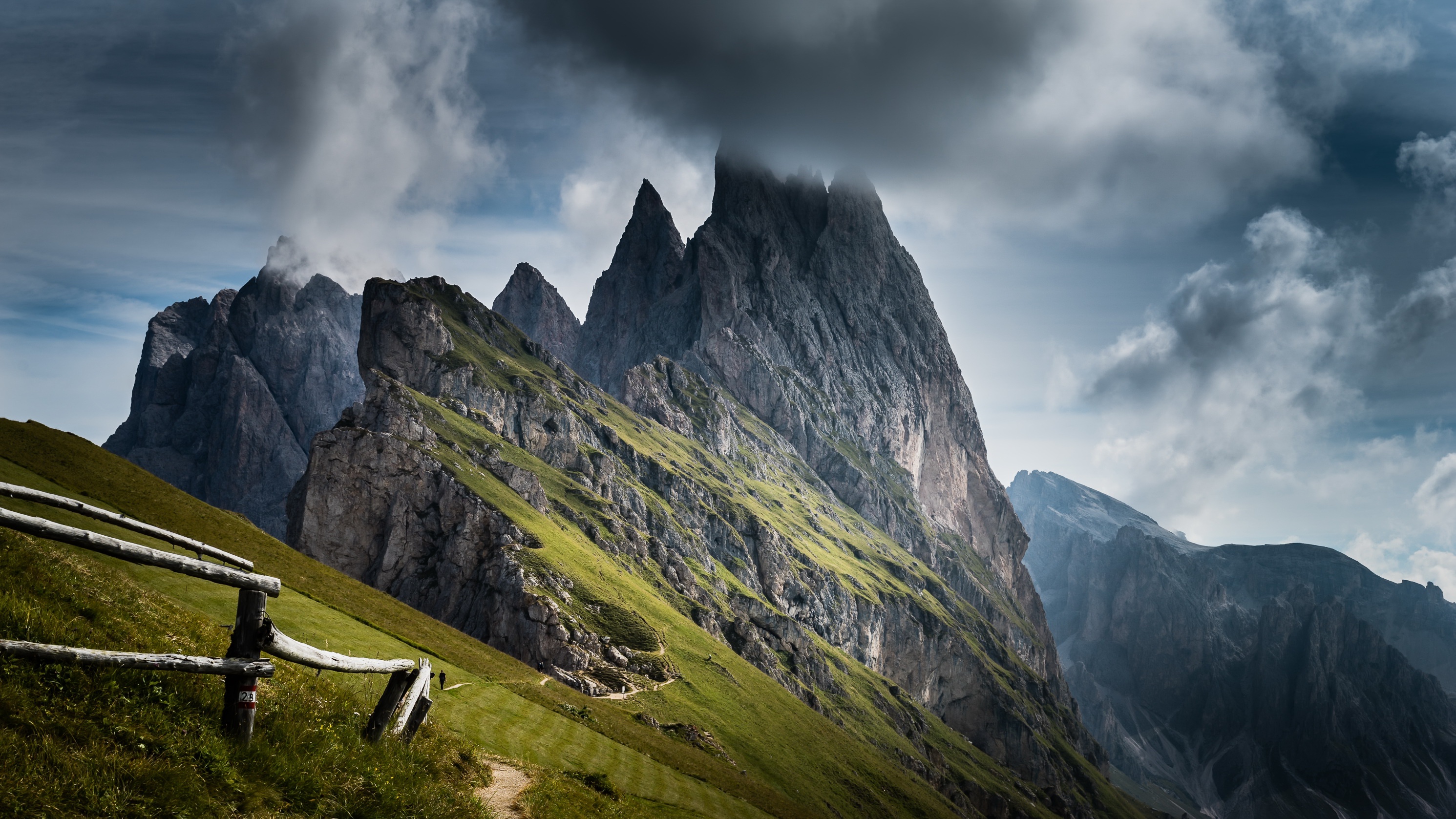 Dramatic mountain peaks under cloudy sky HD Wallpaper