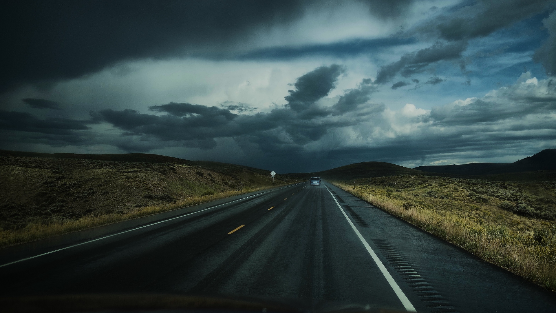 Stormy clouds over a highway in a rural landscape HD Wallpaper