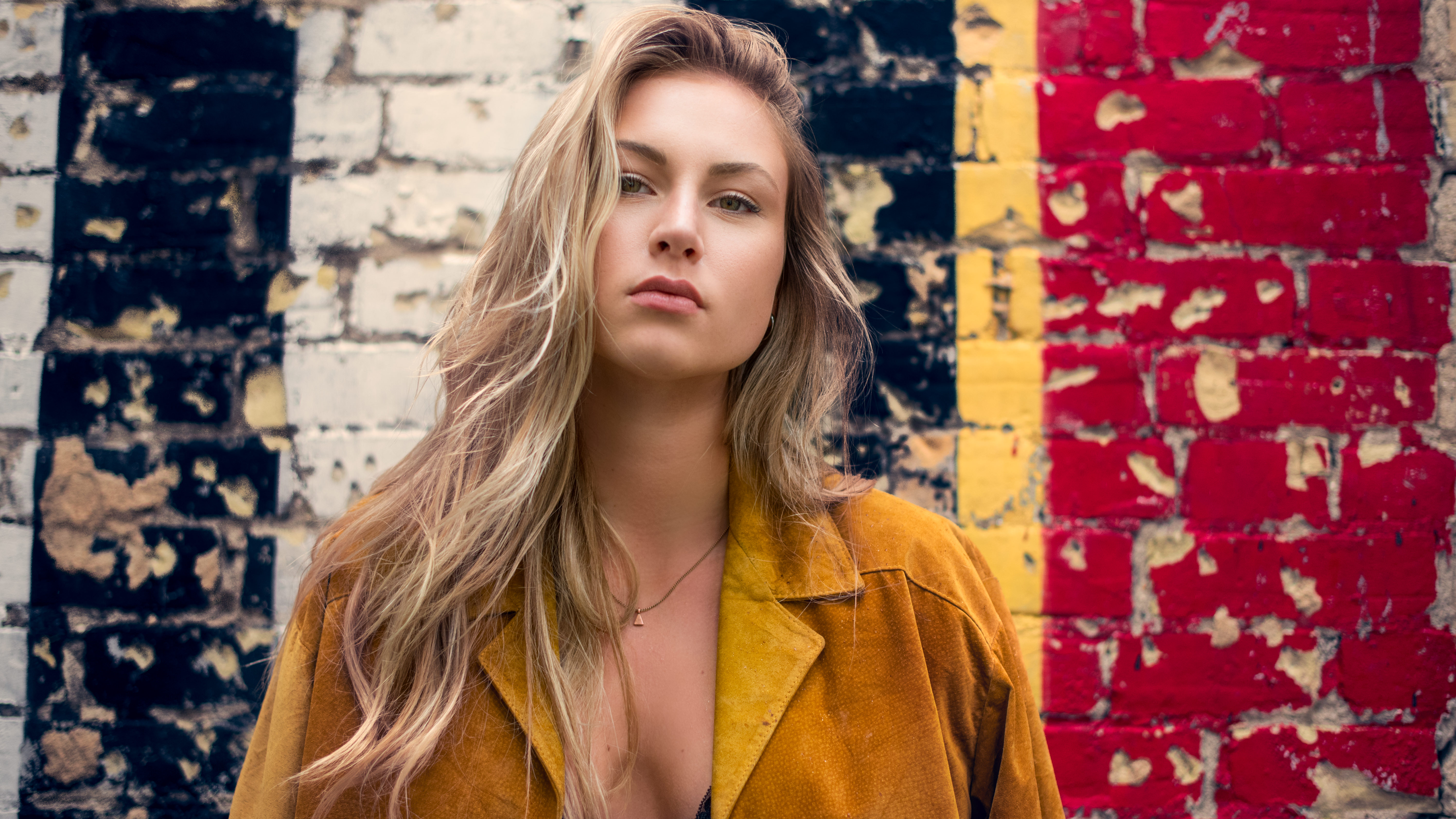 Woman with blonde hair in front of a brick wall HD Wallpaper