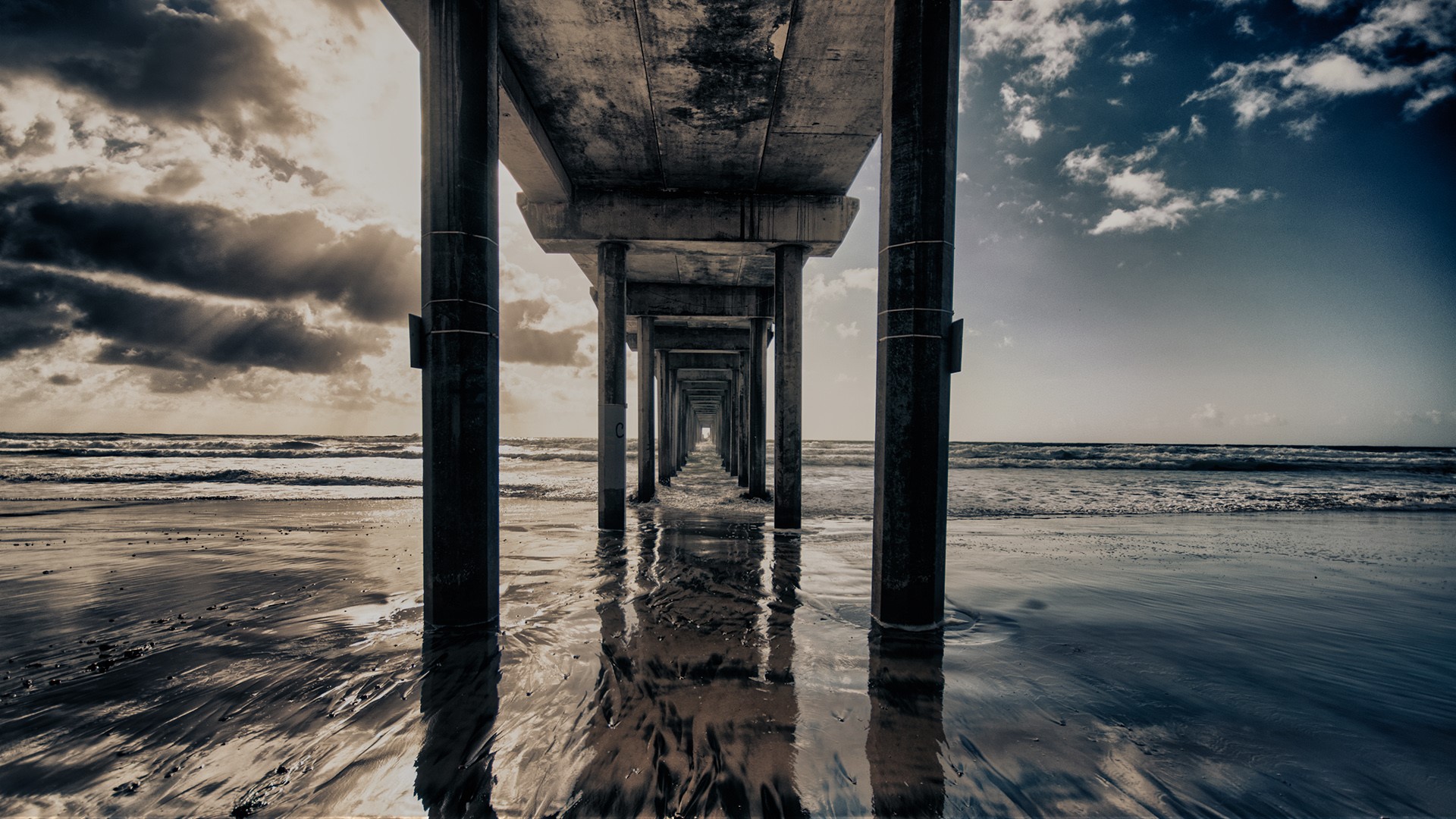 Perspective view under a pier on a beach HD Wallpaper