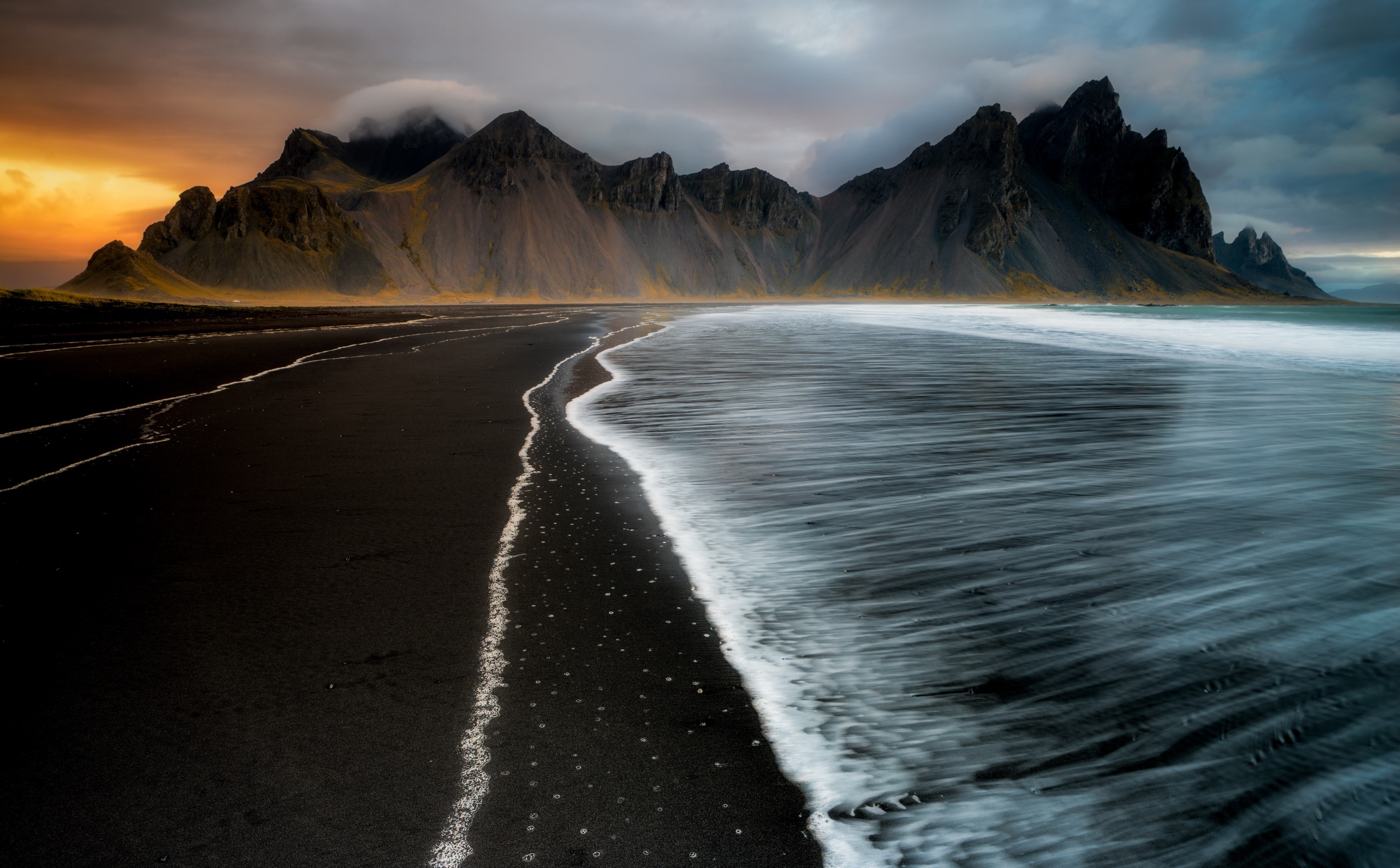 Black sand beach with mountains and ocean waves HD Wallpaper