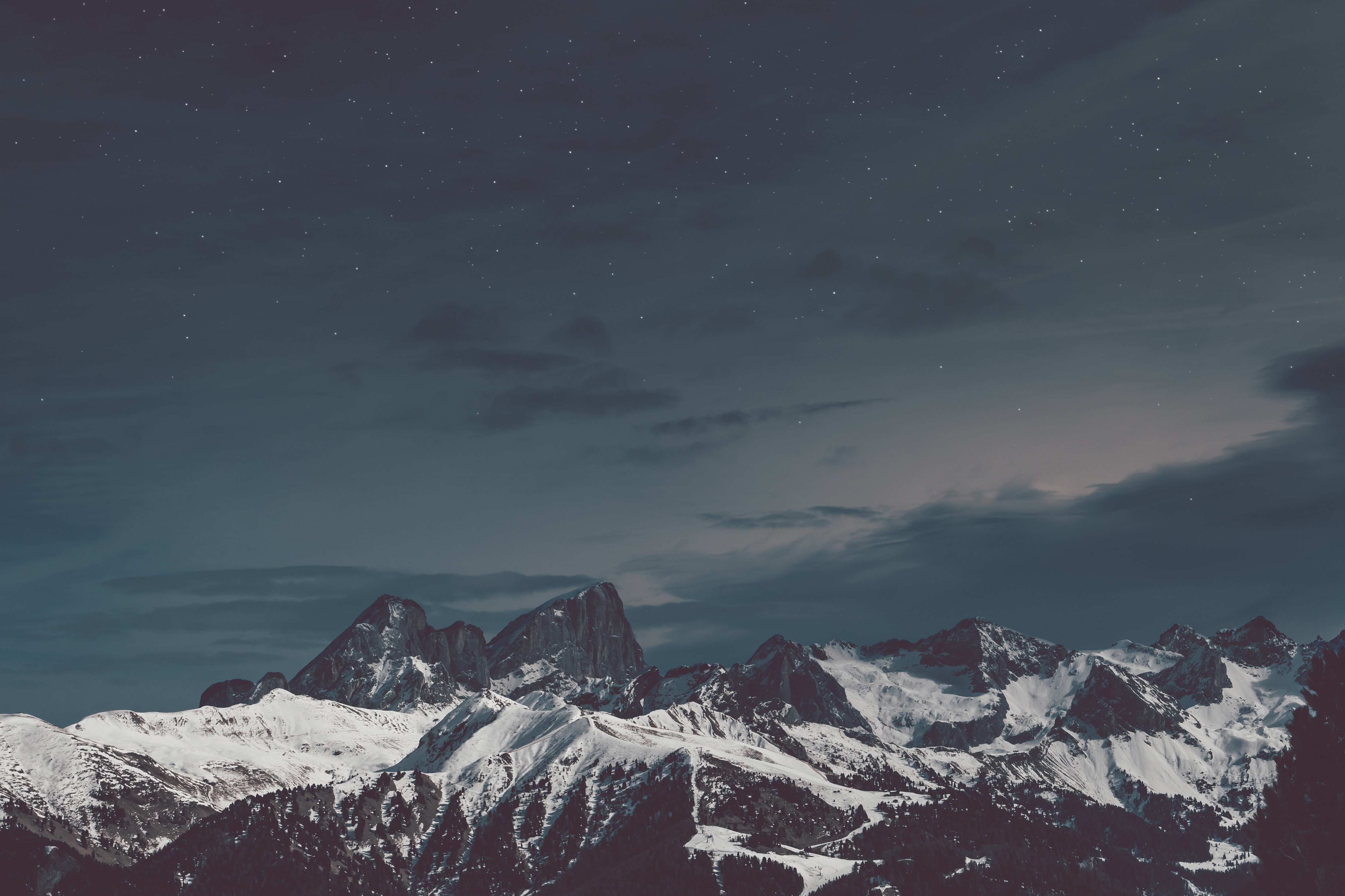 Snow-covered mountains under a starry night sky HD Wallpaper