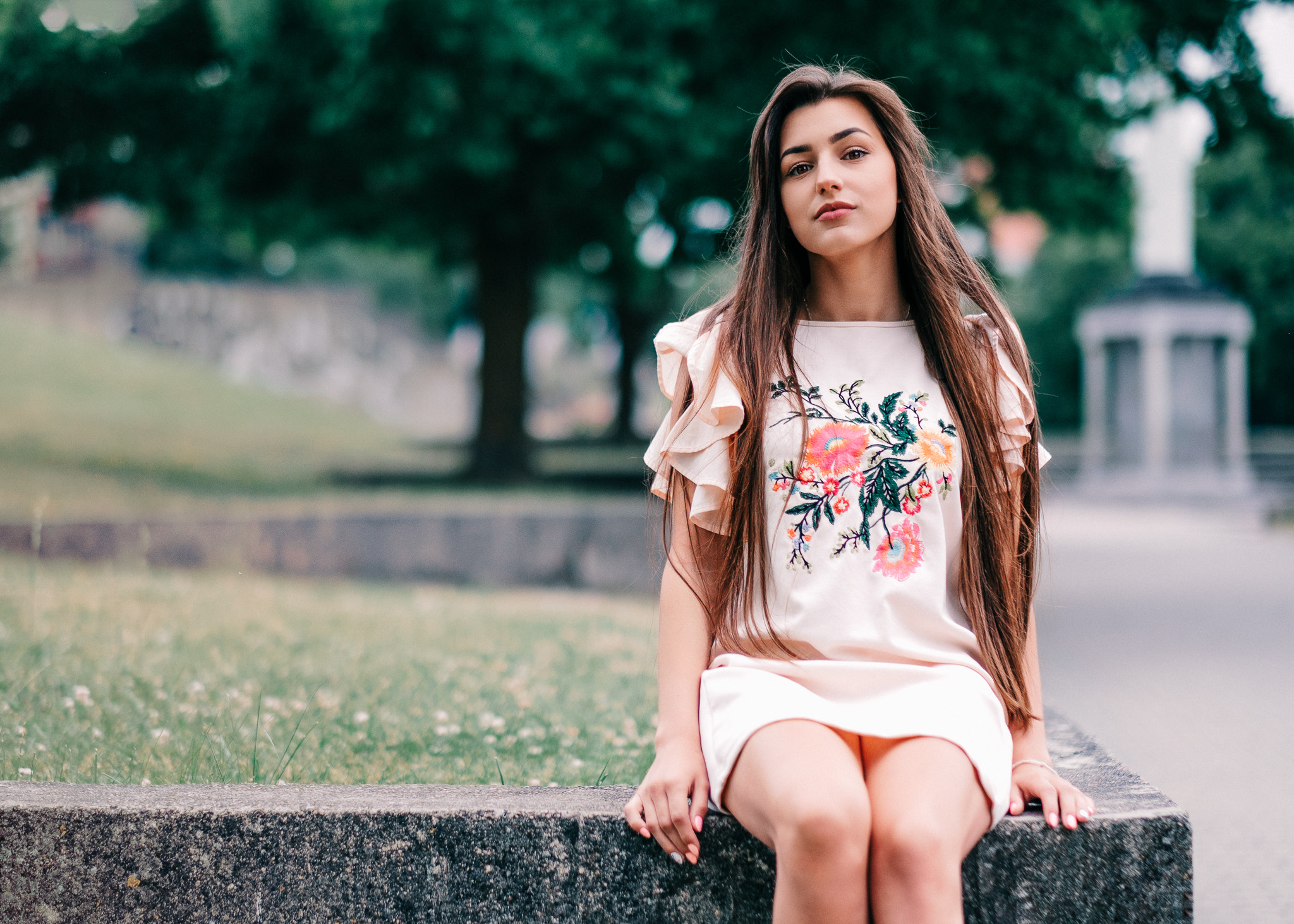 Woman in floral dress sitting outdoors HD Wallpaper