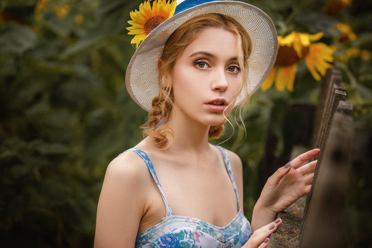 Woman with sunflower in hat in garden HD Wallpaper