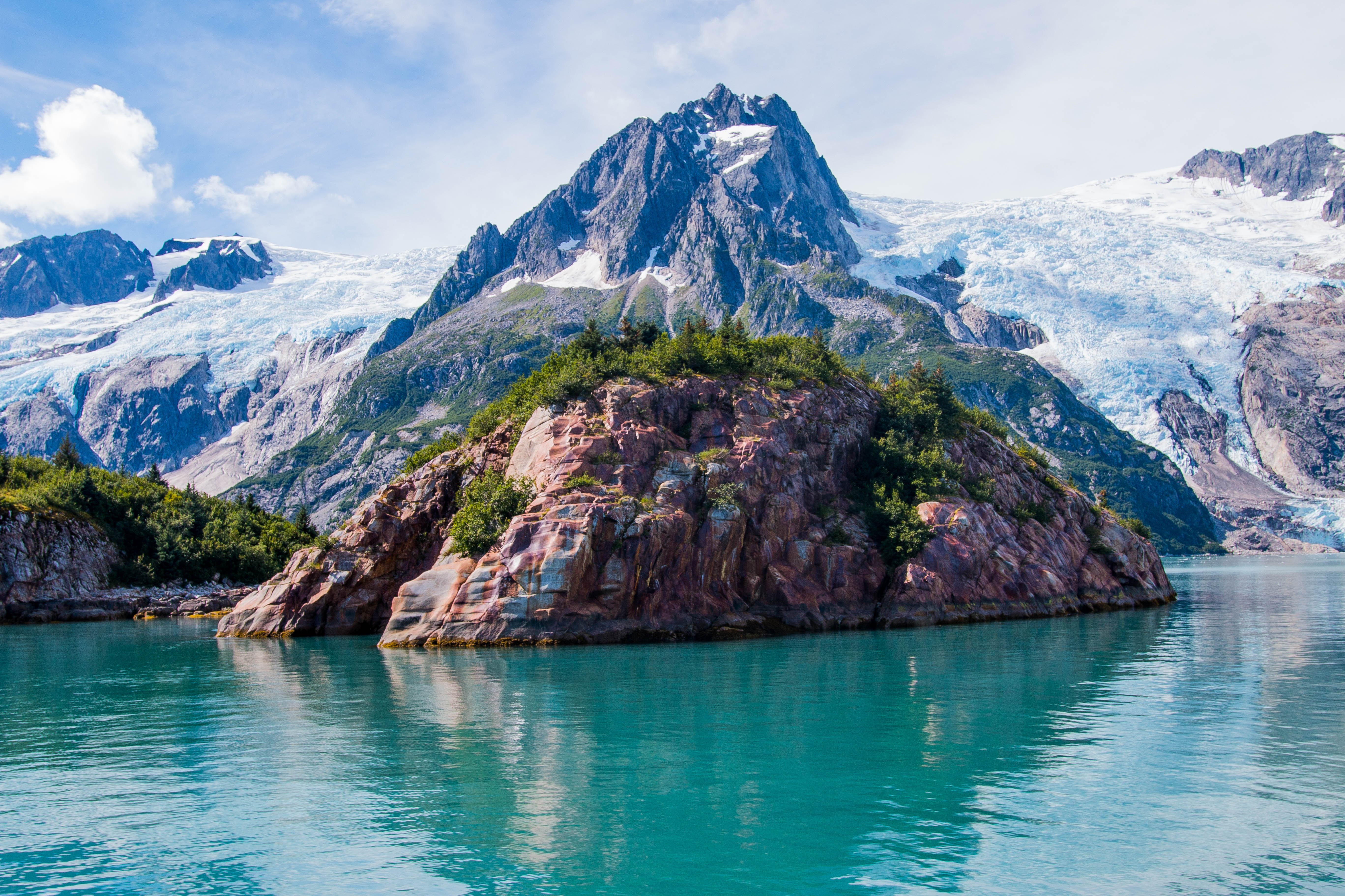 Rocky island and glacier in a turquoise lake HD Wallpaper