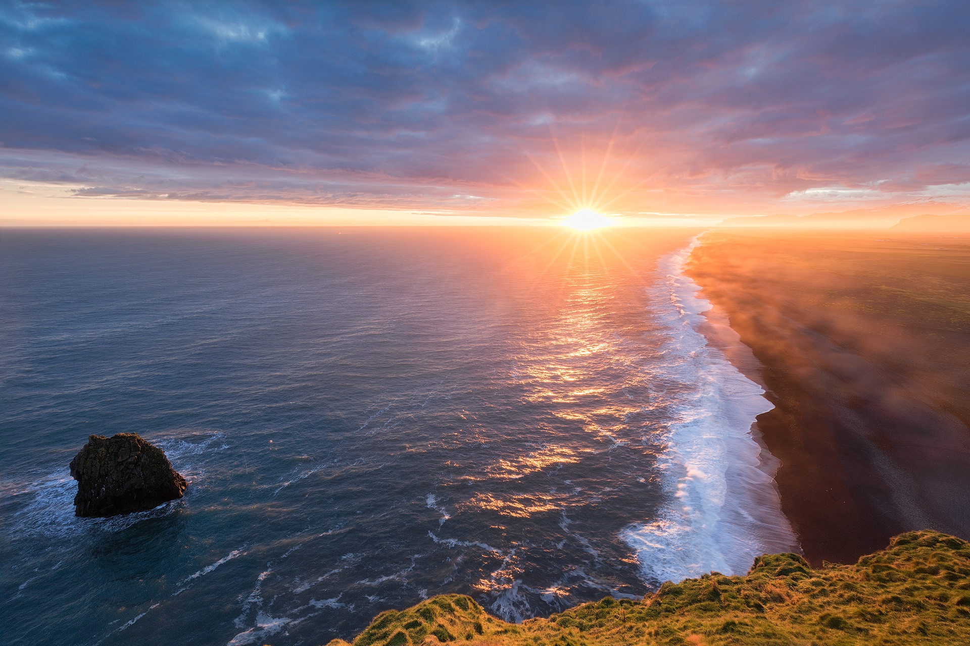 Sunset over the ocean and a black sand beach HD Wallpaper