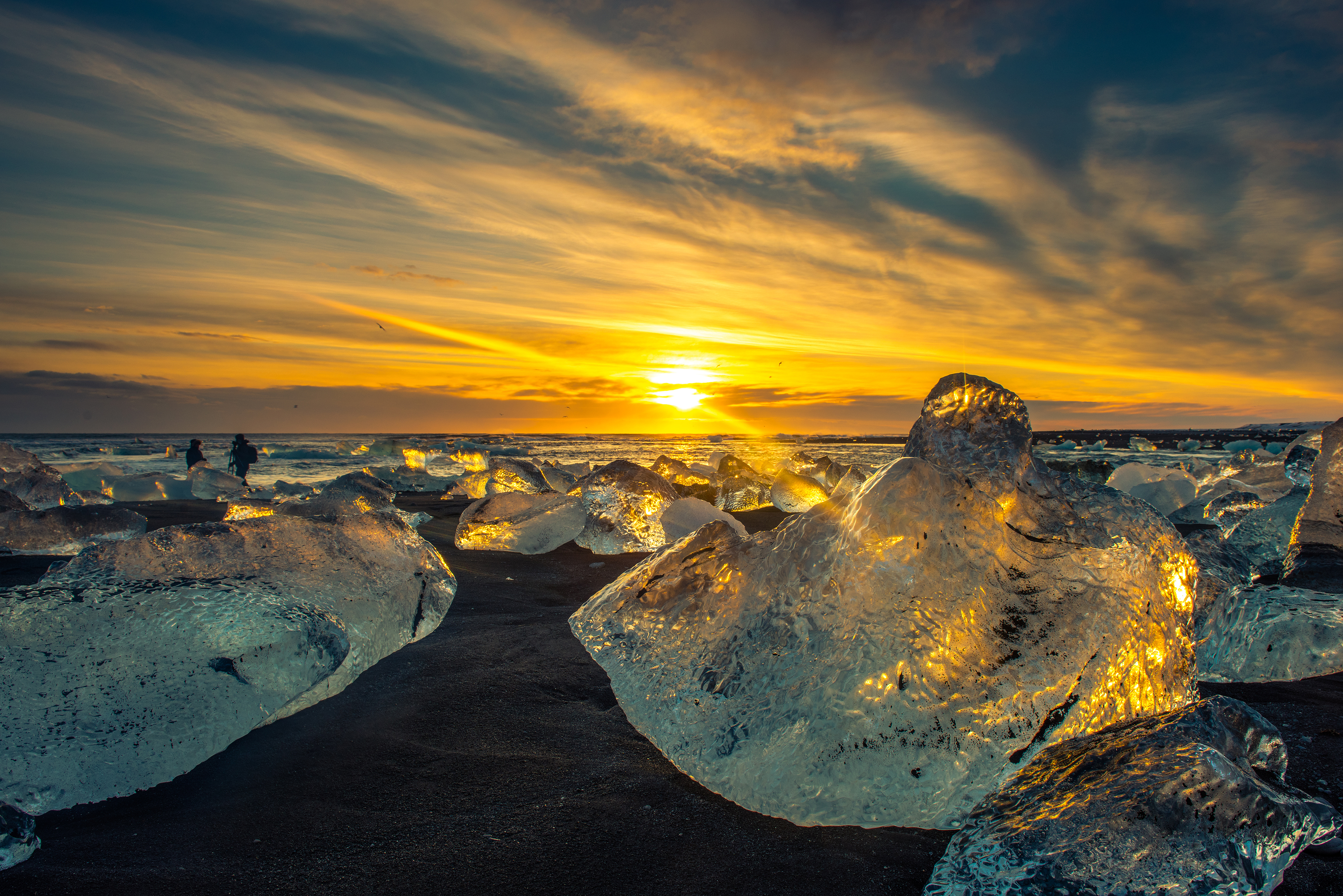 Icebergs on a black sand beach at sunset HD Wallpaper