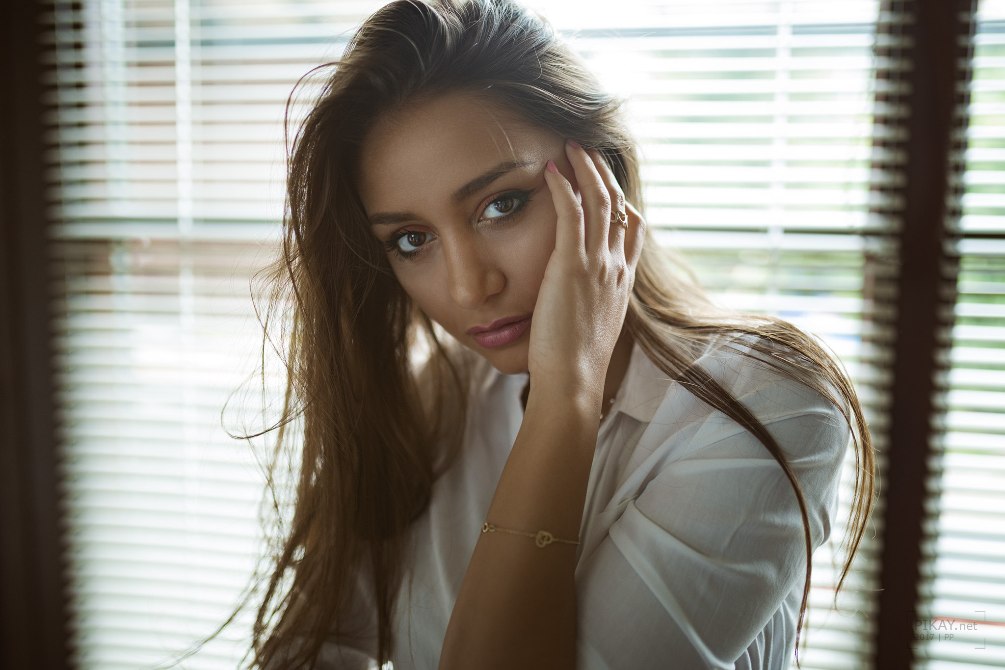 Tanned woman in white shirt by window HD Wallpaper