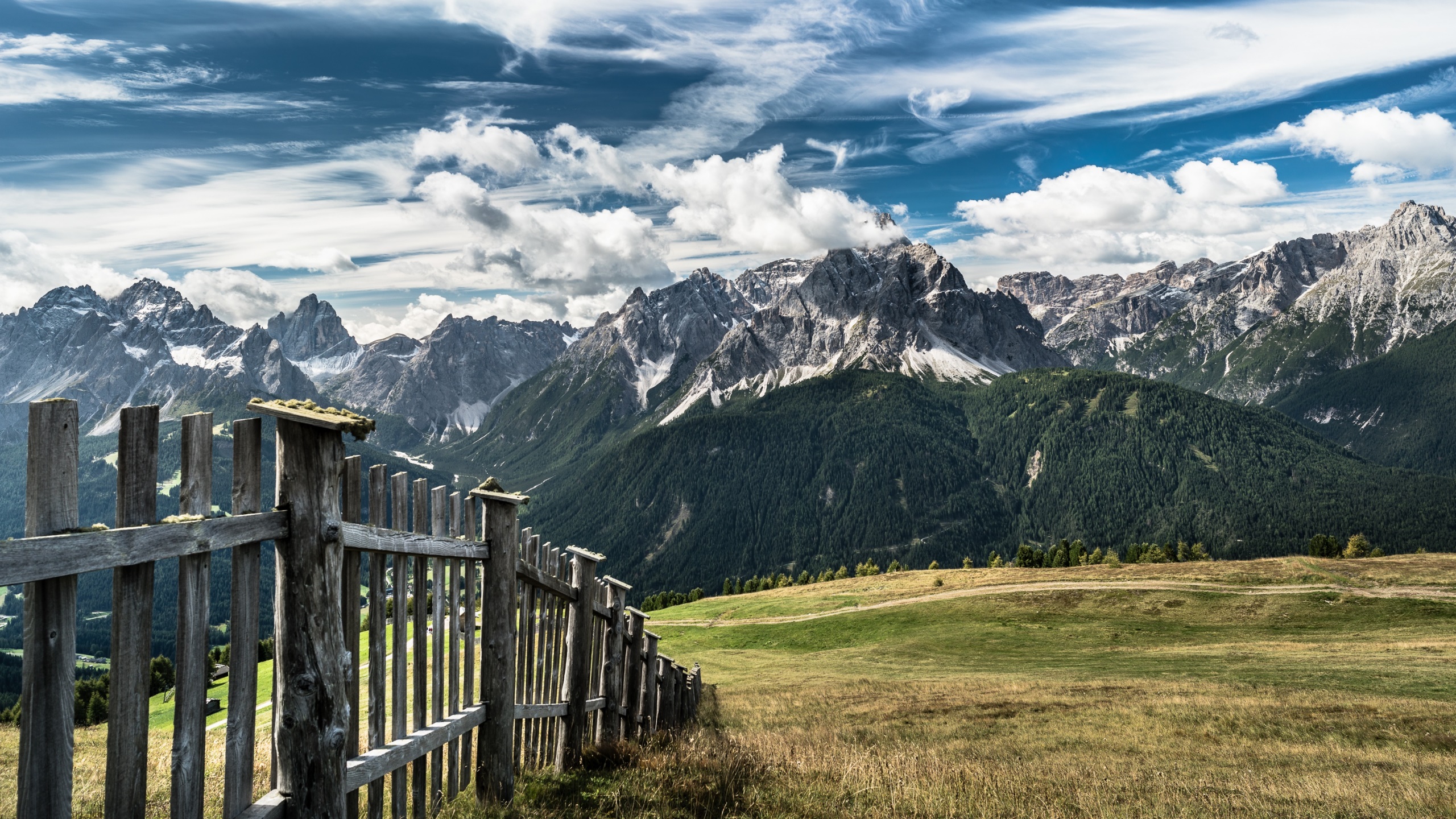 Wooden fence in front of mountains under a cloudy sky HD Wallpaper