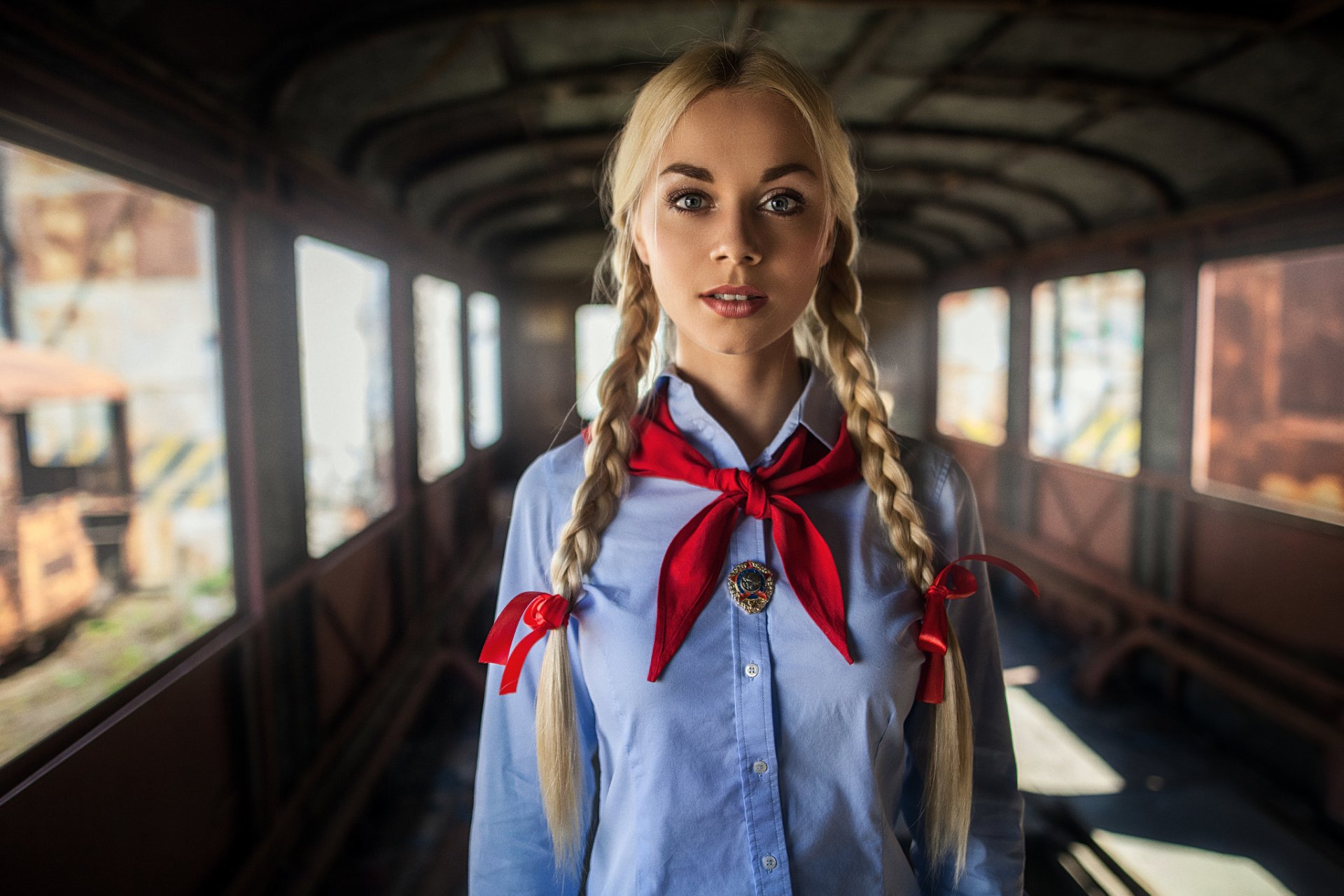 Woman with blonde pigtails and red scarf in train car HD Wallpaper