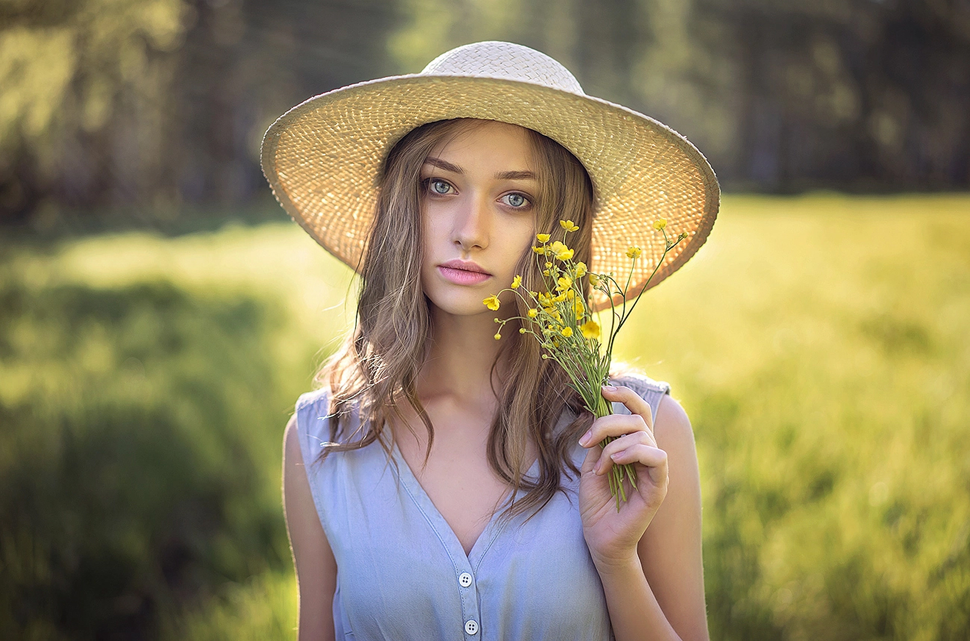 Woman in straw hat holding yellow flowers outdoors HD Wallpaper