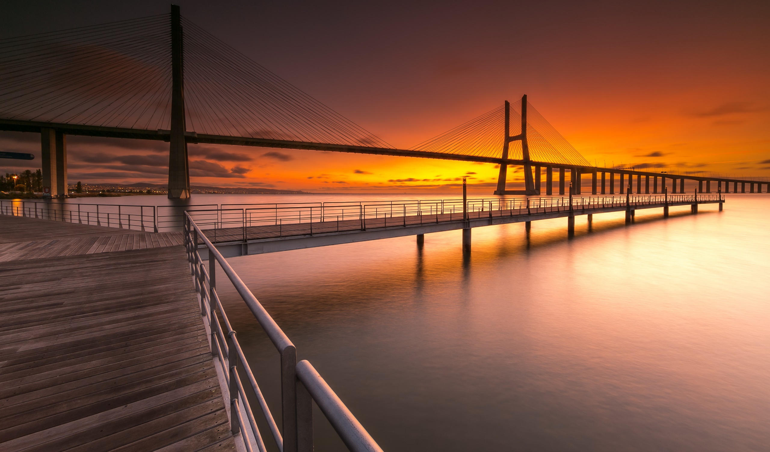 Vasco da Gama Bridge over water at sunset HD Wallpaper