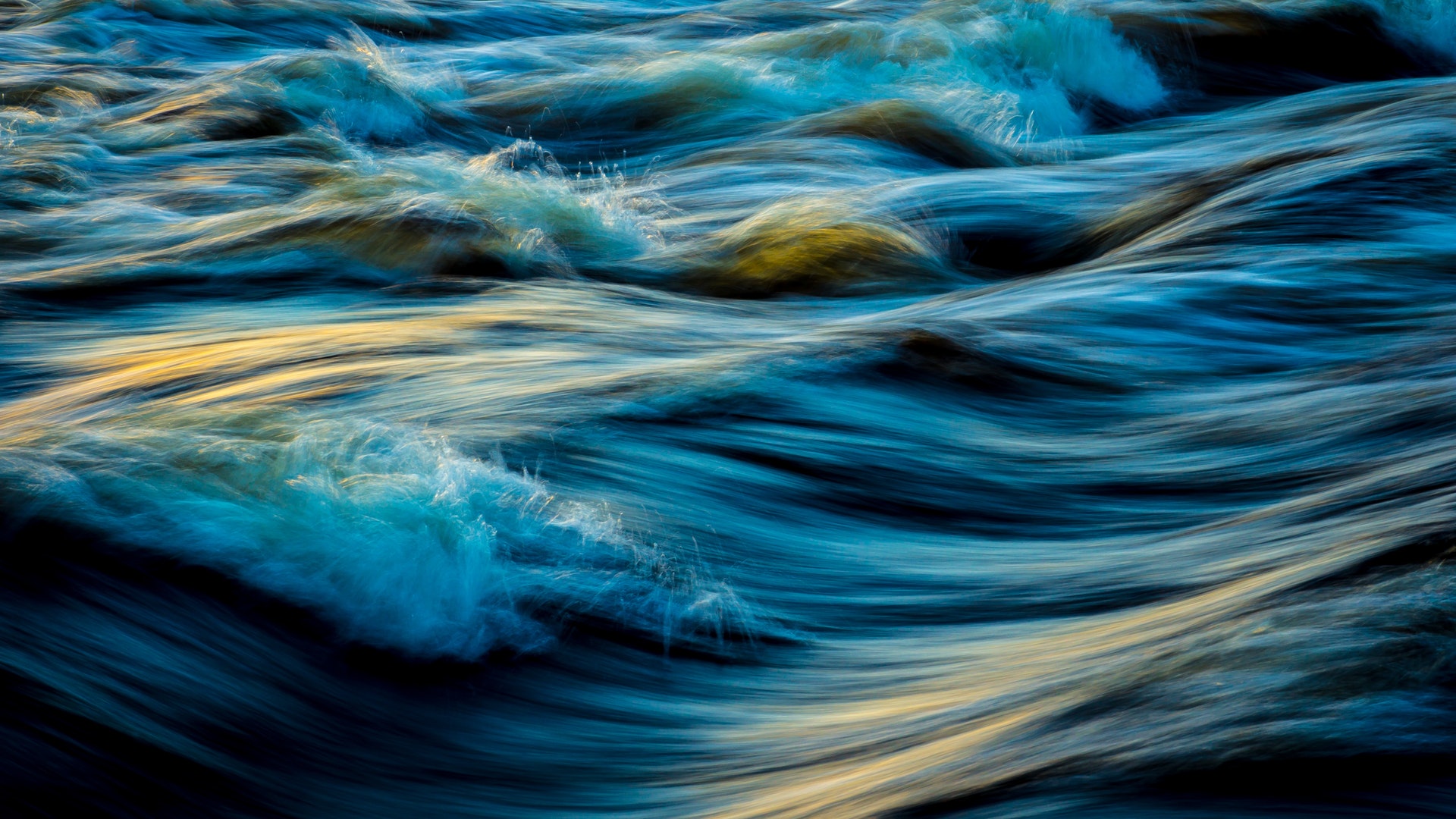 Long exposure of blue ocean waves with golden light HD Wallpaper