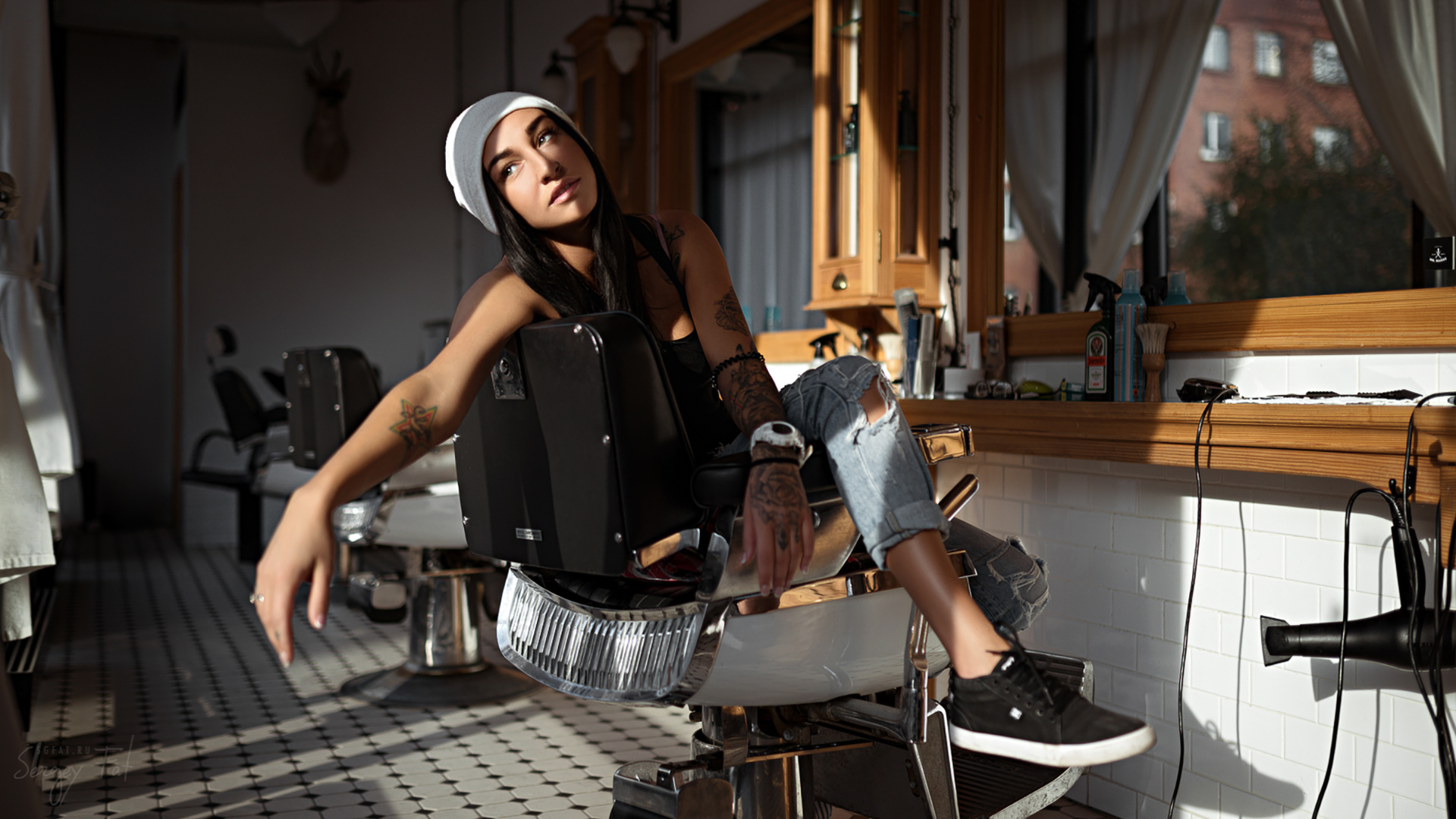 Woman with tattoos sitting in a barber chair HD Wallpaper