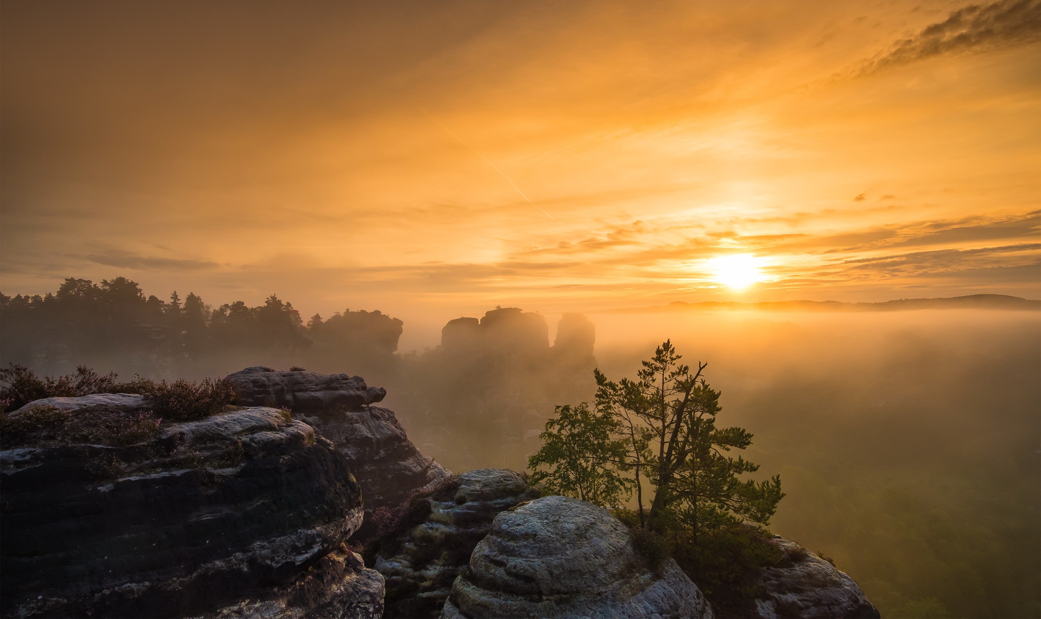 Sunrise over misty mountains and rock formations HD Wallpaper