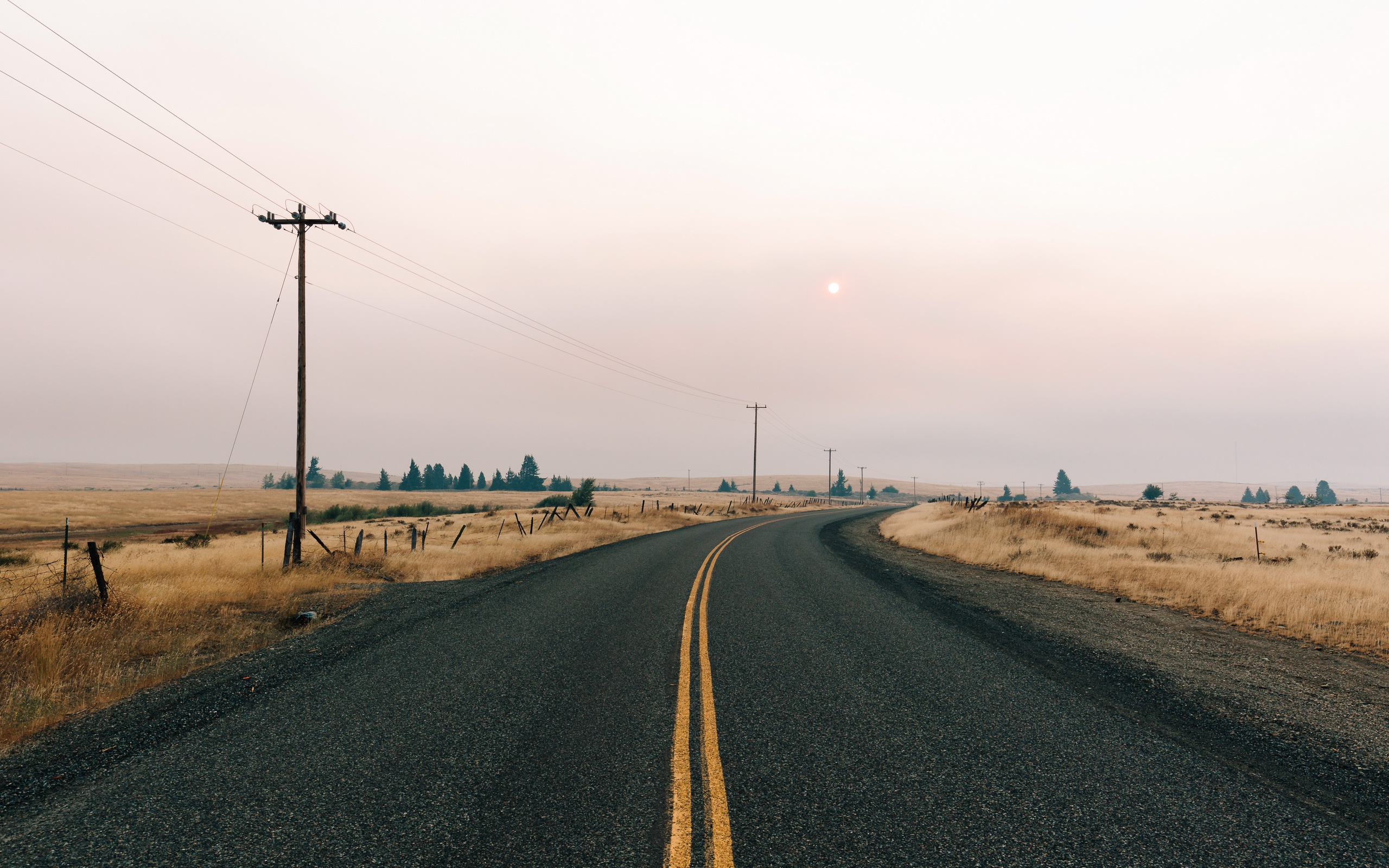 Empty road through a dry landscape with telephone poles HD Wallpaper