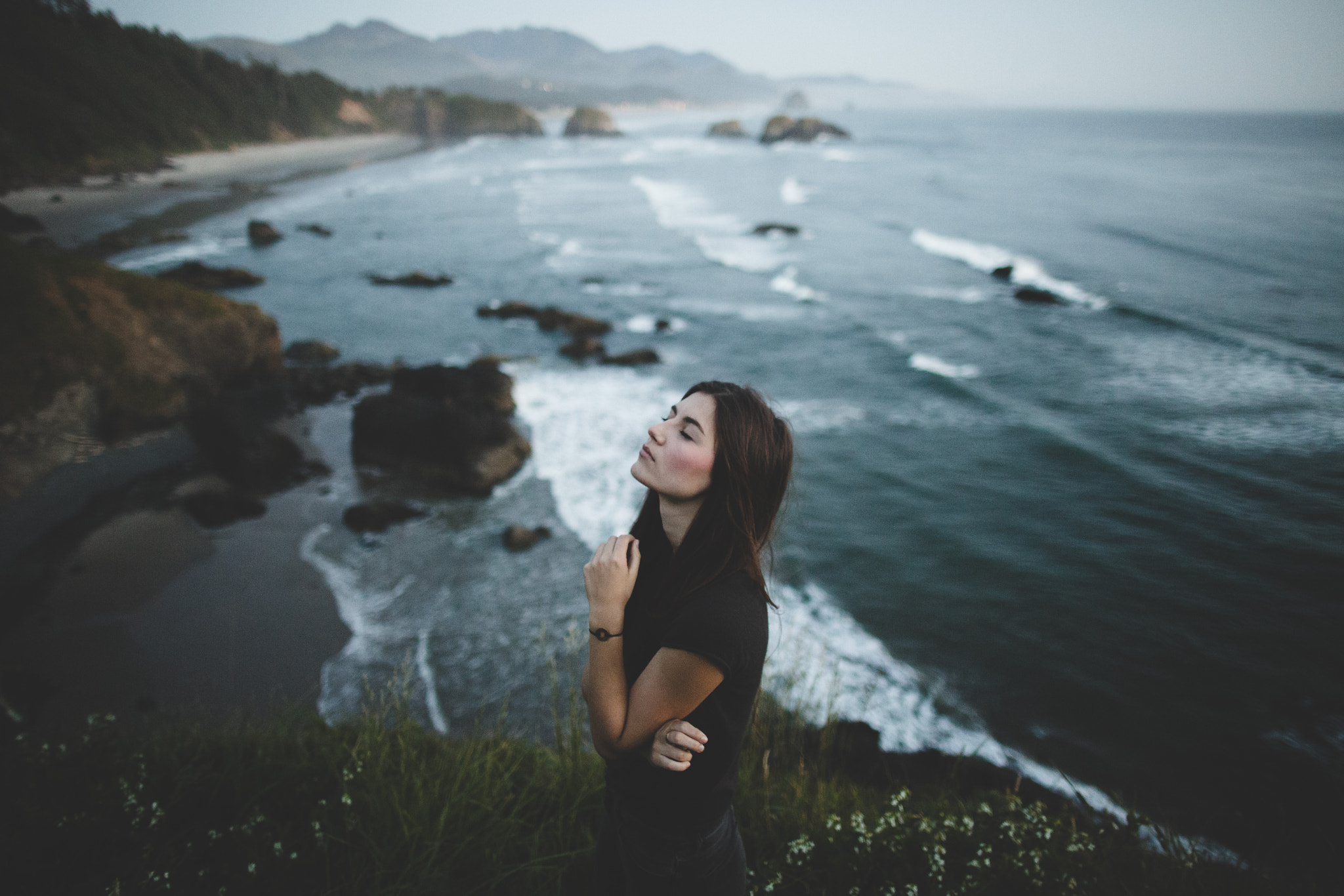 Woman on a cliff overlooking the ocean HD Wallpaper