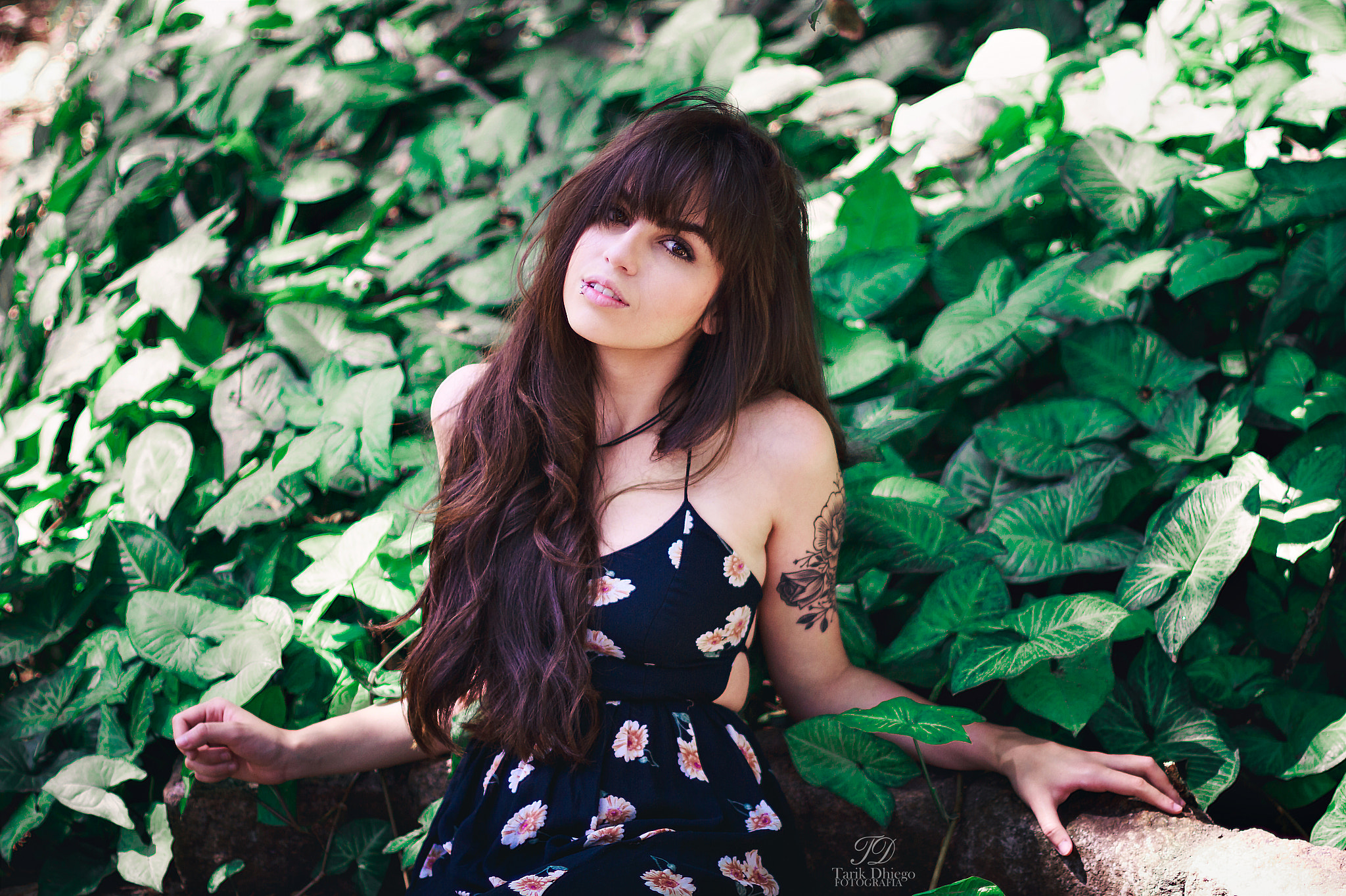 Woman with tattoo in a floral dress among plants HD Wallpaper