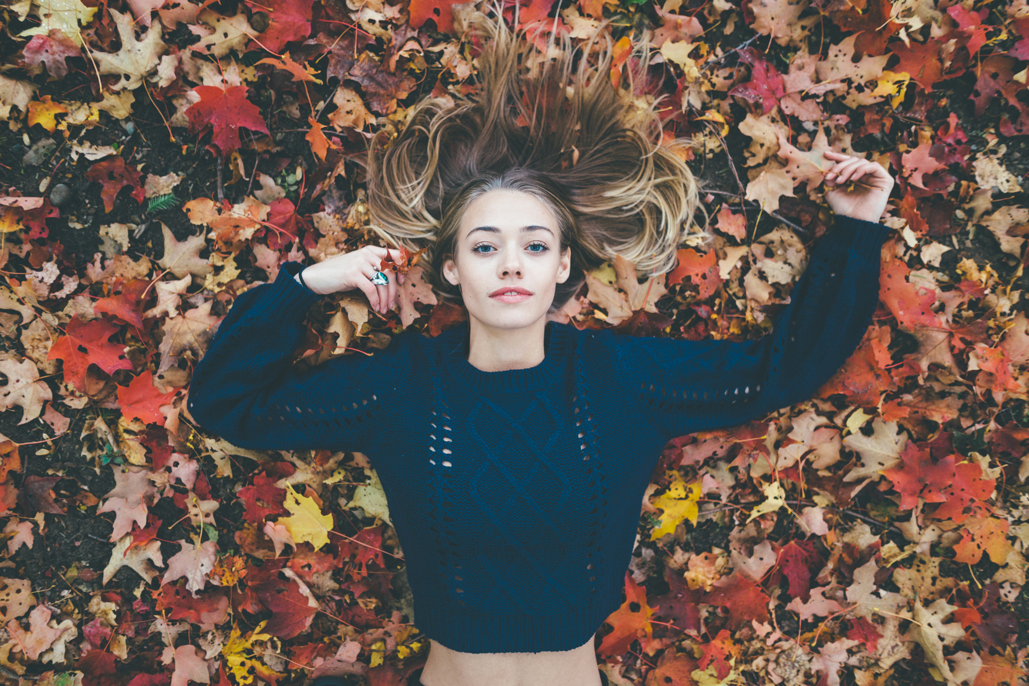 Woman lying on autumn leaves HD Wallpaper