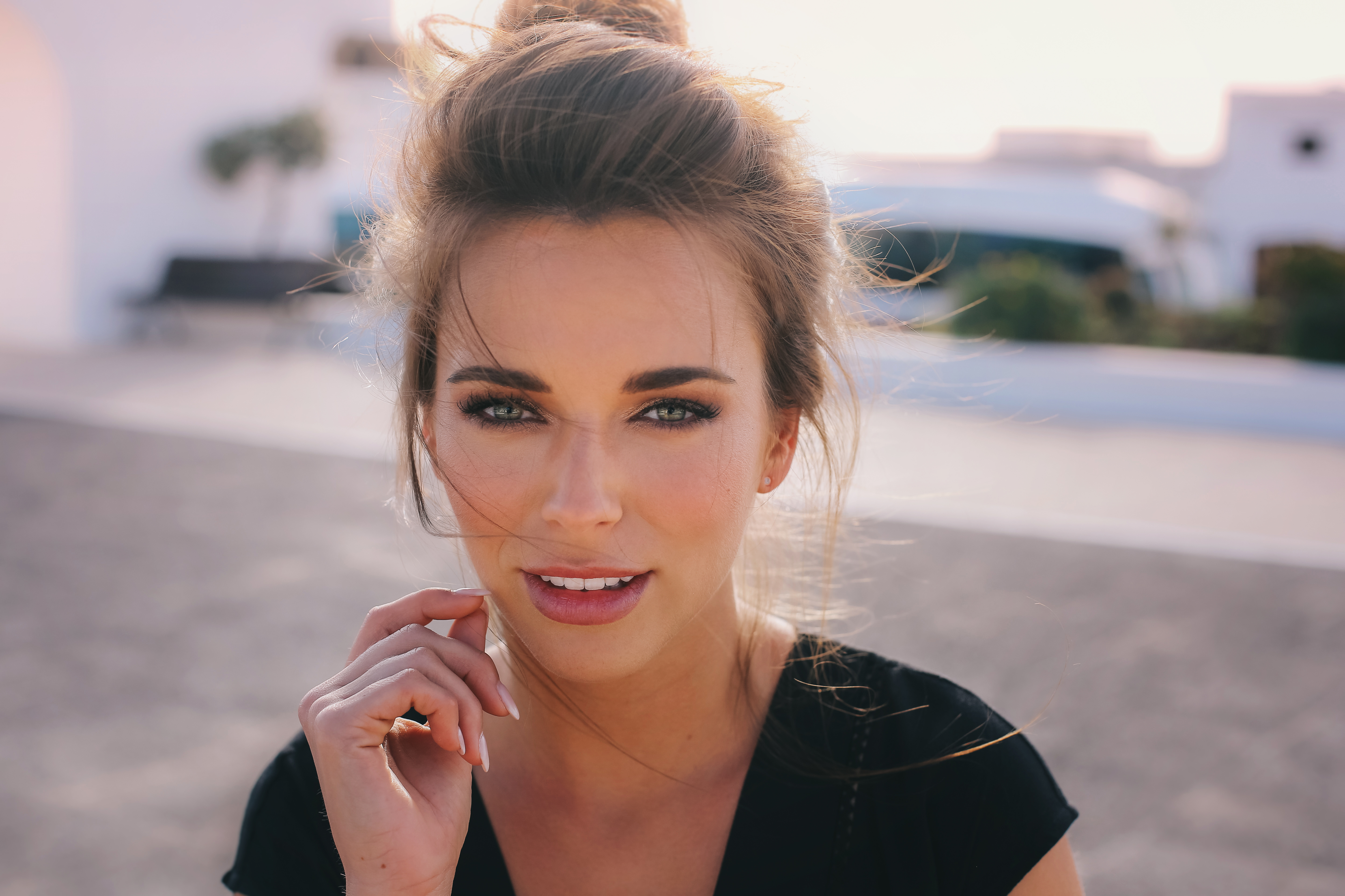 Woman with green eyes and hair in a bun looking at viewer HD Wallpaper