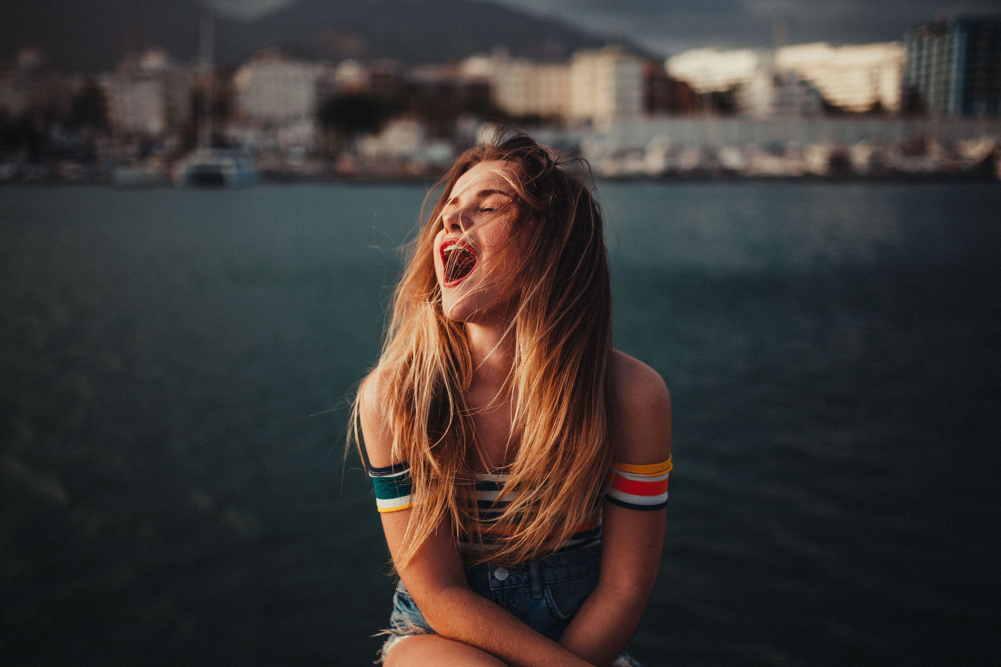Young woman with blonde hair shouting by the water HD Wallpaper