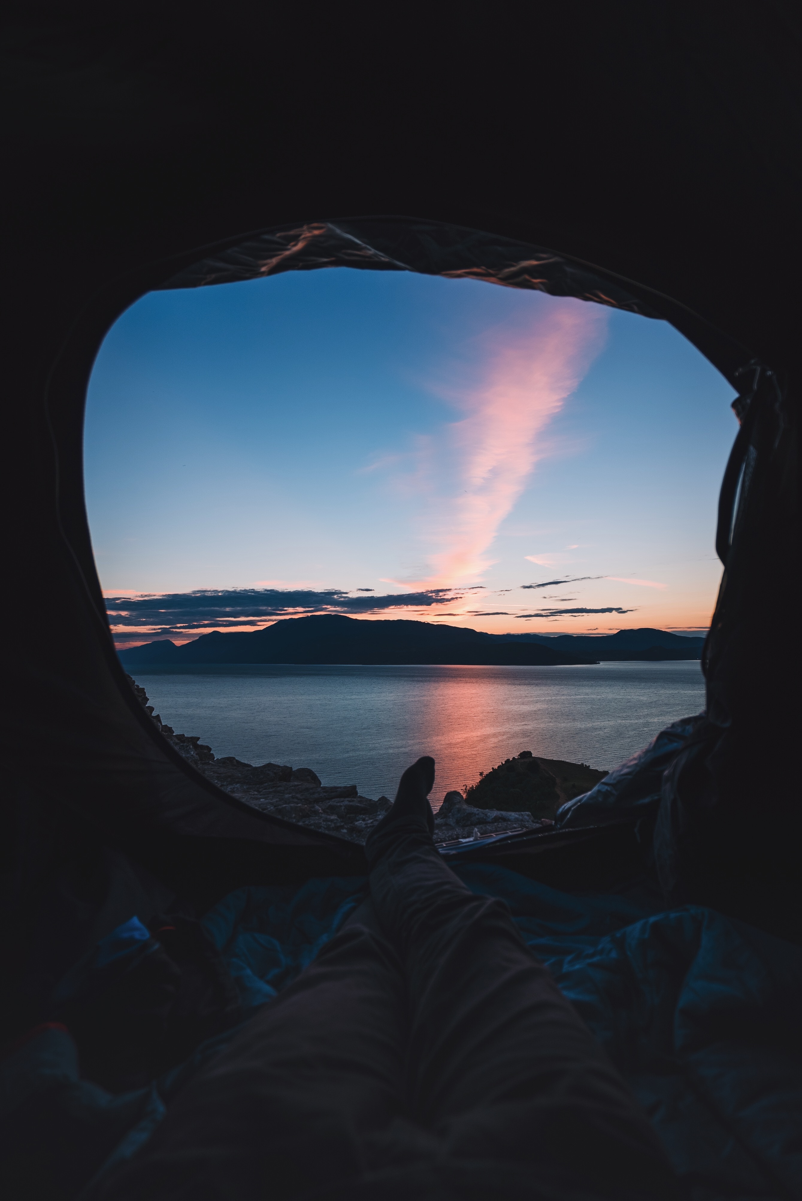 View from tent at sunset over water and mountains HD Wallpaper