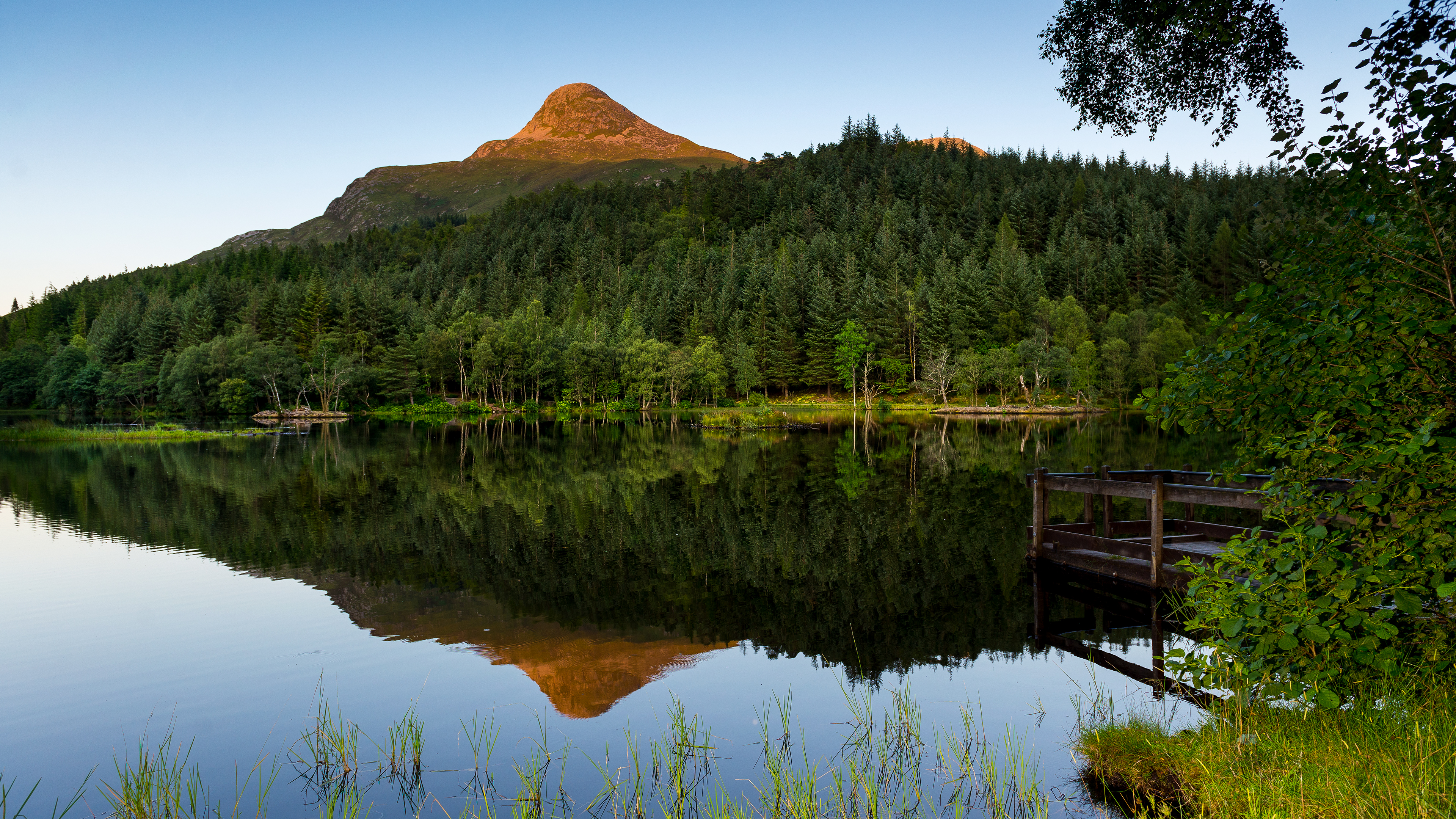 Mountain reflected in a lake with a wooden pier HD Wallpaper