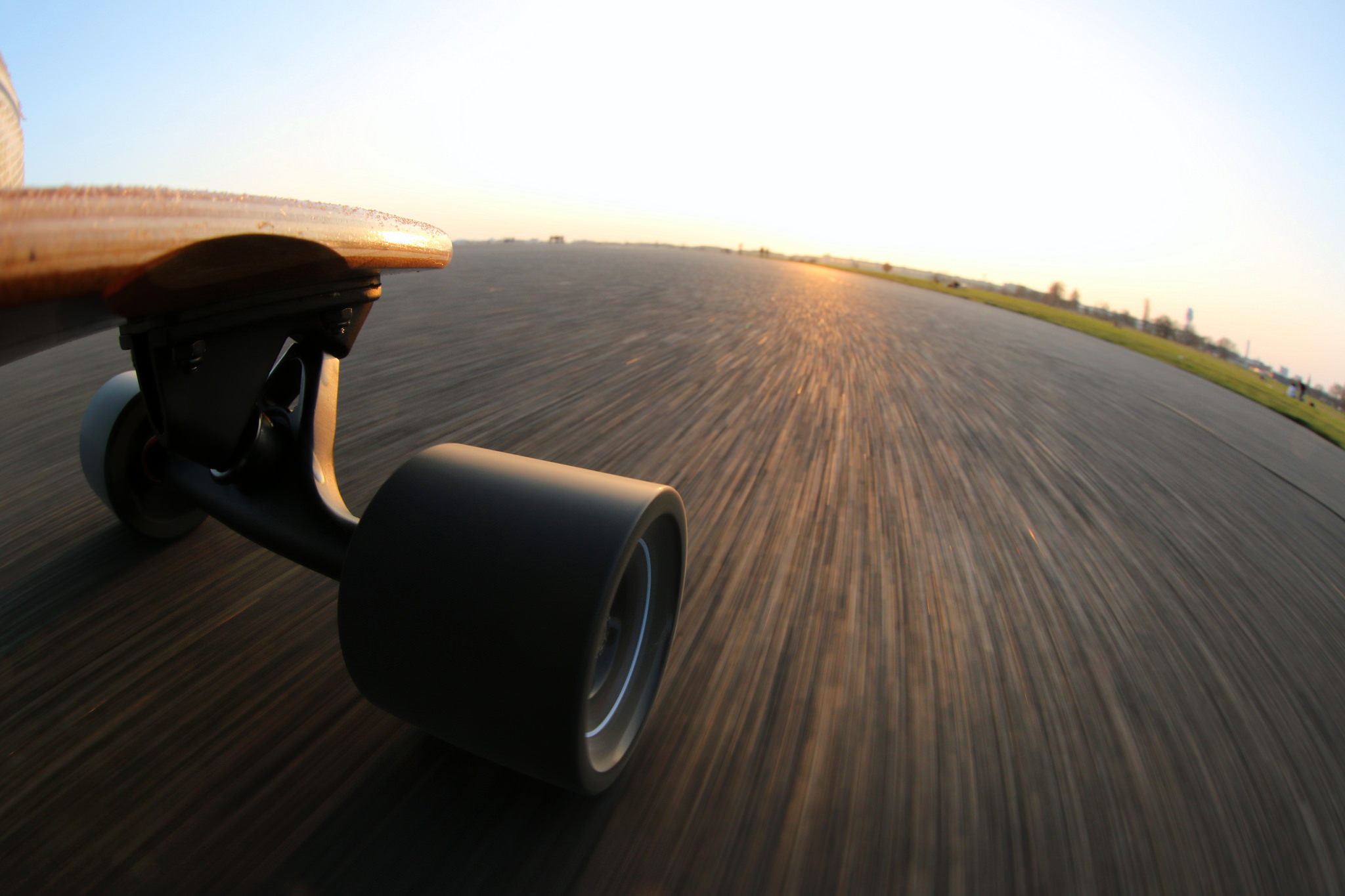 Skateboard riding on asphalt road at sunset HD Wallpaper