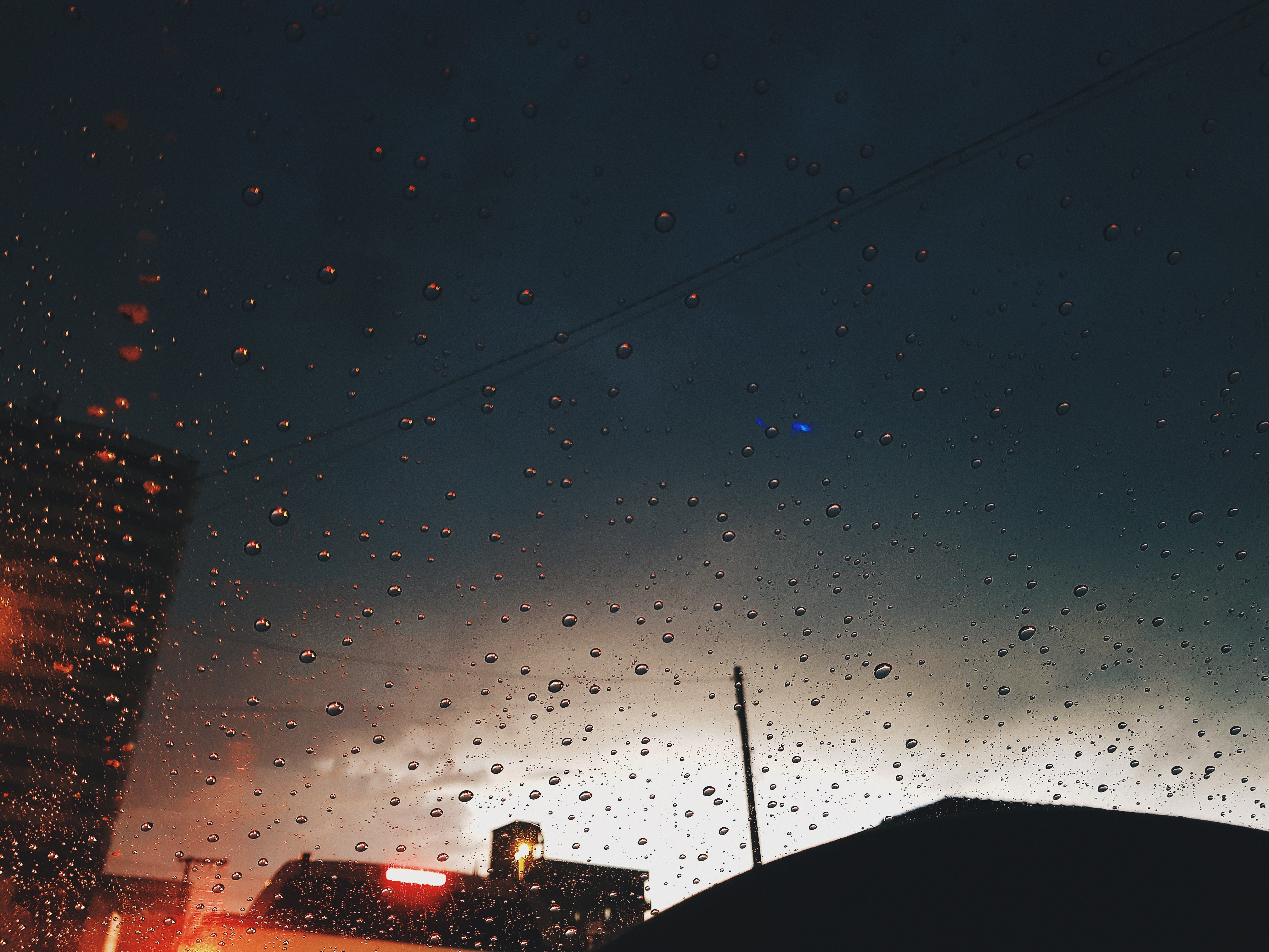 Raindrops on a window overlooking a city at dusk HD Wallpaper