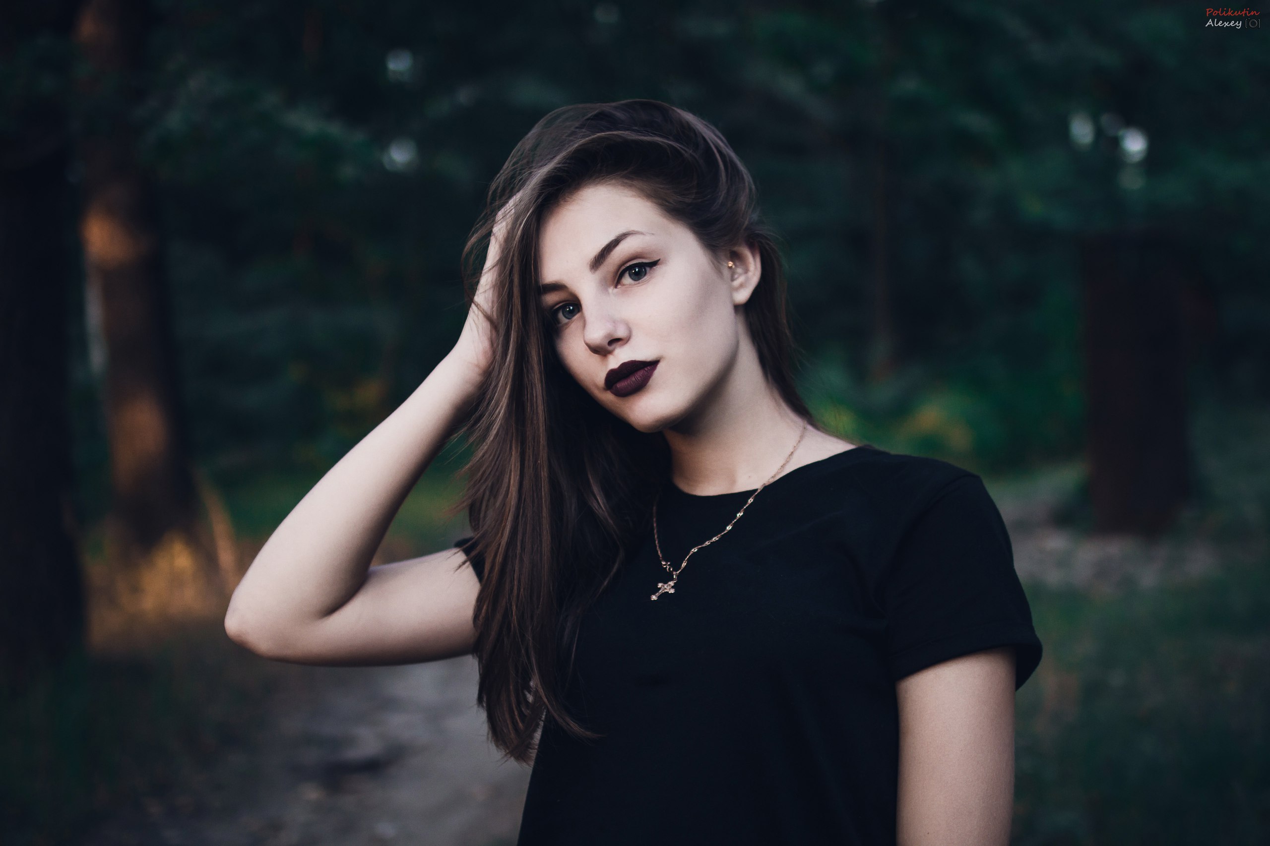 Woman with dark lipstick and necklace in forest HD Wallpaper