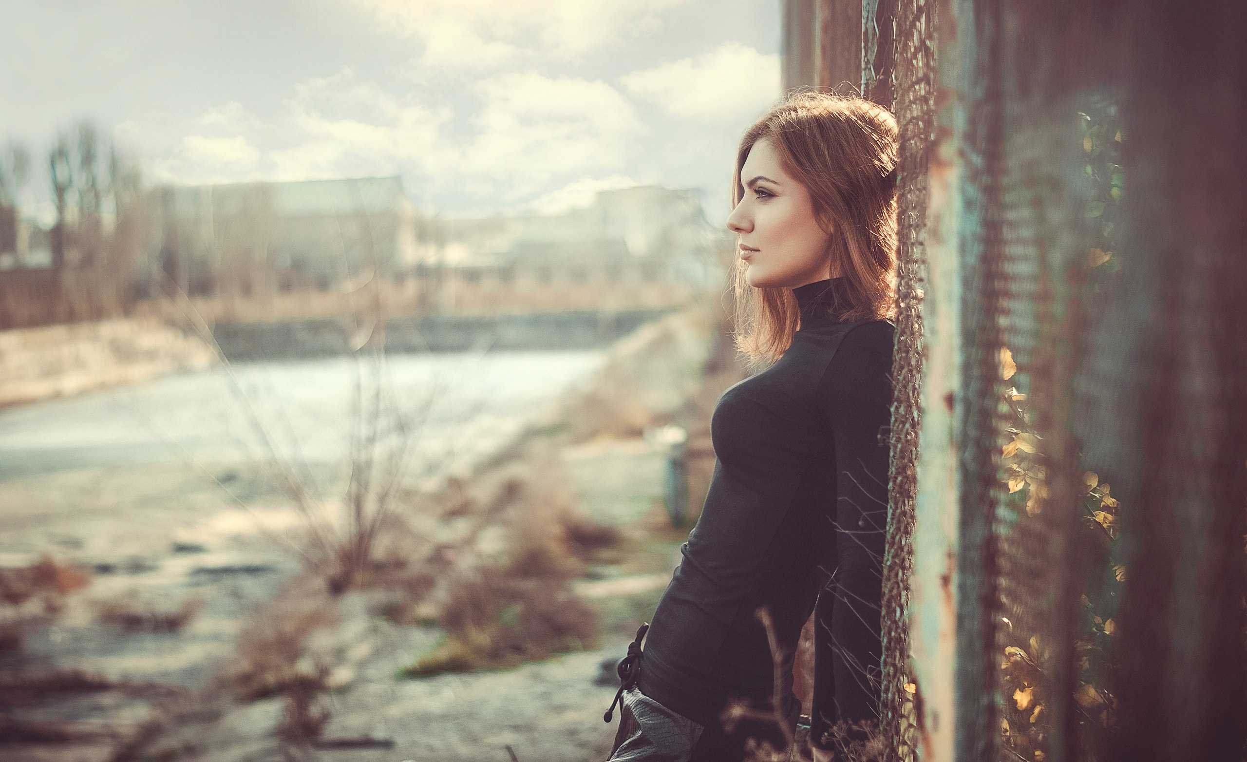 Woman in black turtleneck leaning against a fence HD Wallpaper
