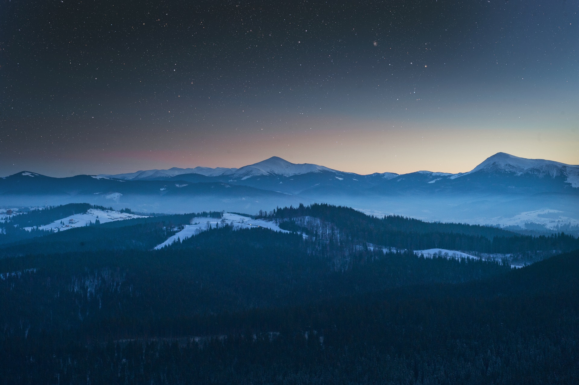 Starry night over snowy mountains and misty forests HD Wallpaper