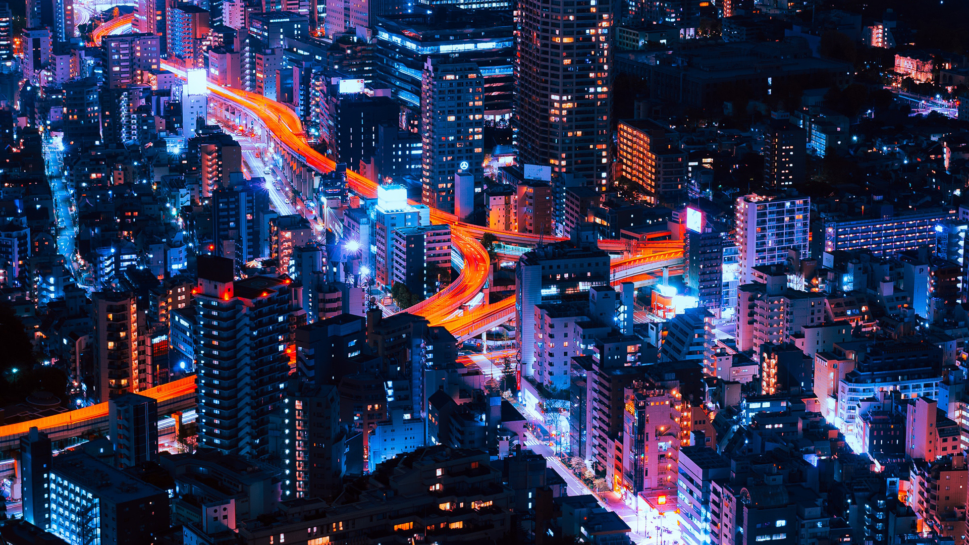 Aerial view of a neon-lit cityscape at night HD Wallpaper