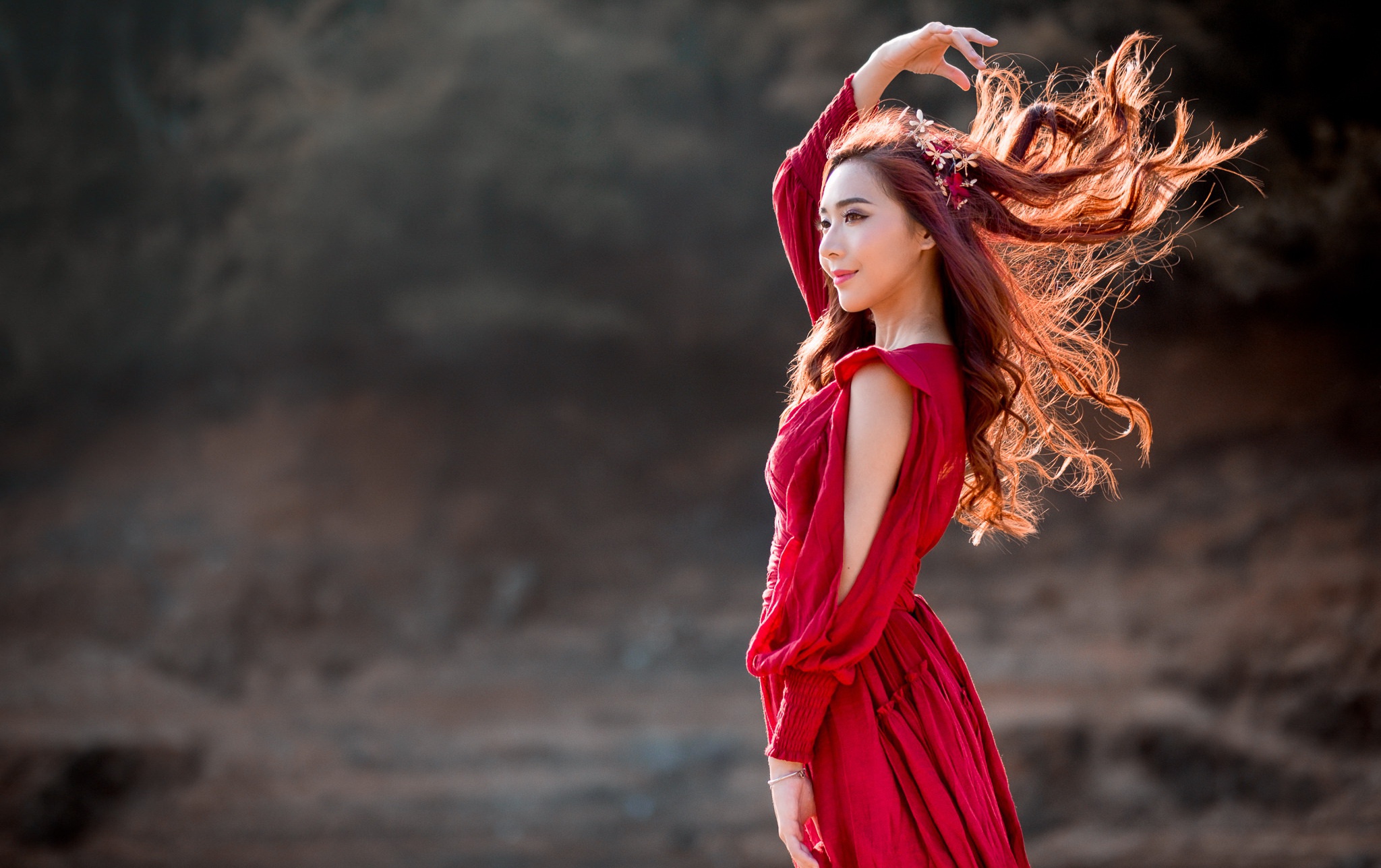 Woman in red dress with windblown hair outdoors HD Wallpaper