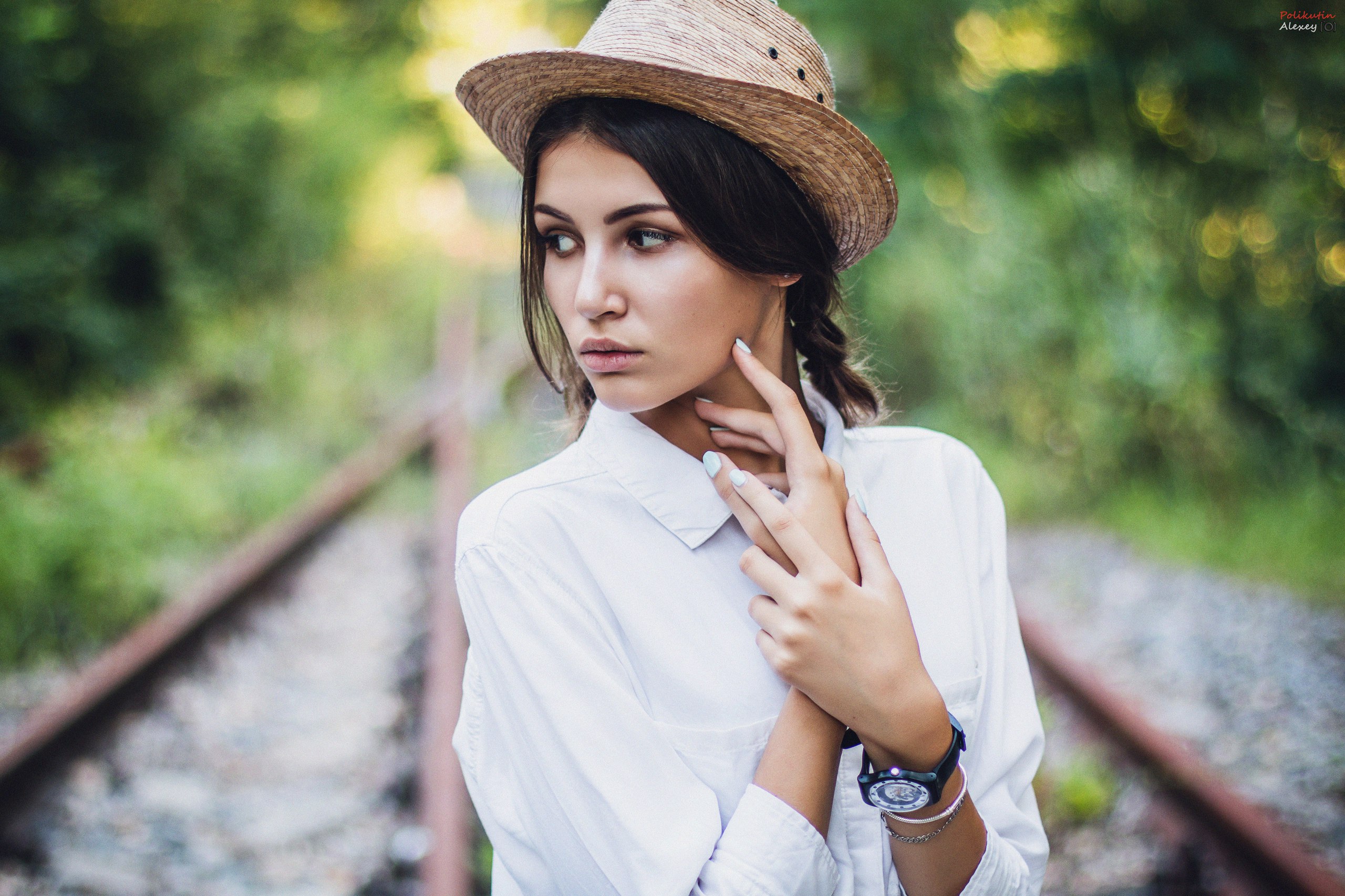 Woman wearing a hat and white shirt on railway tracks HD Wallpaper