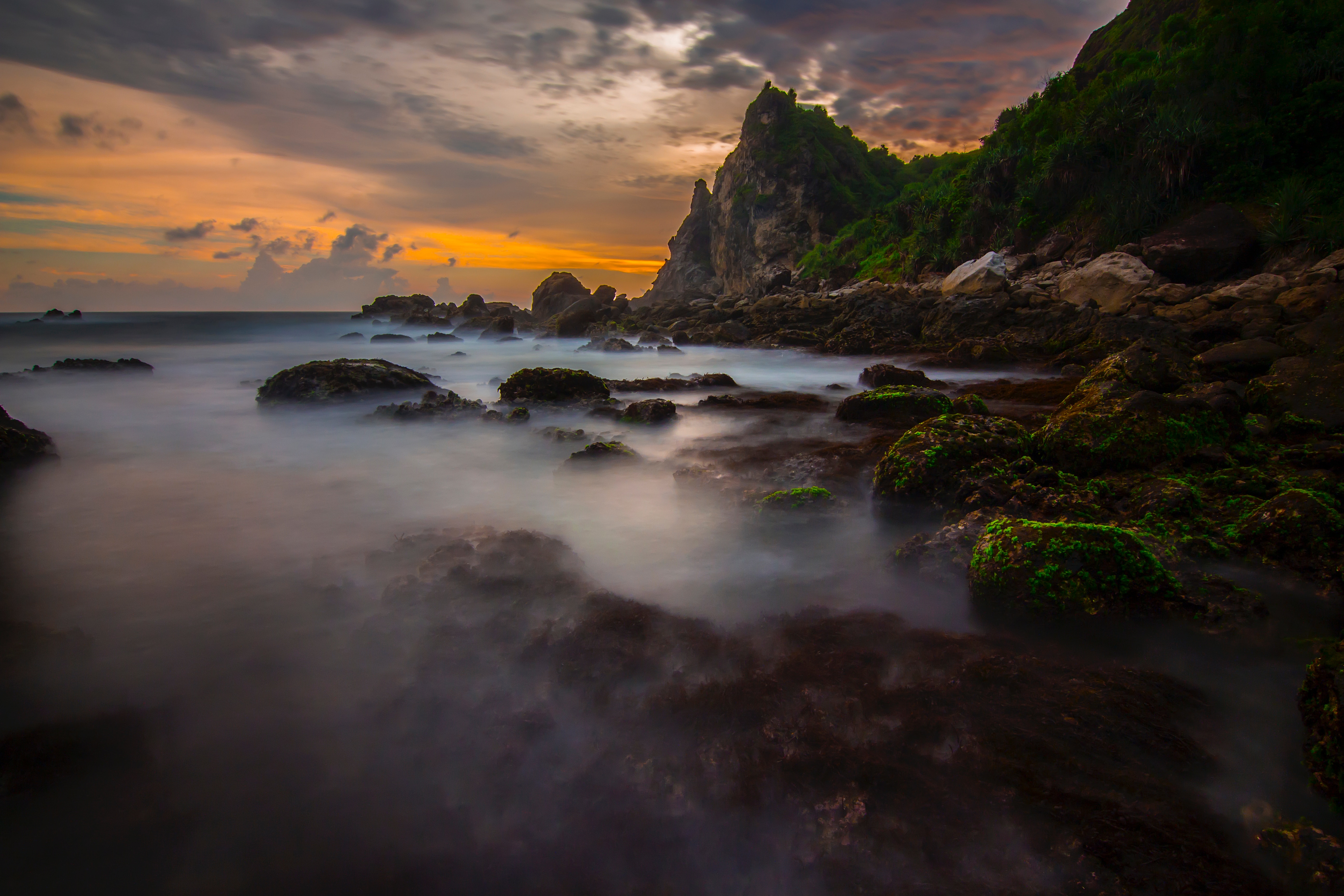 Rocky coastline with misty ocean at sunset HD Wallpaper
