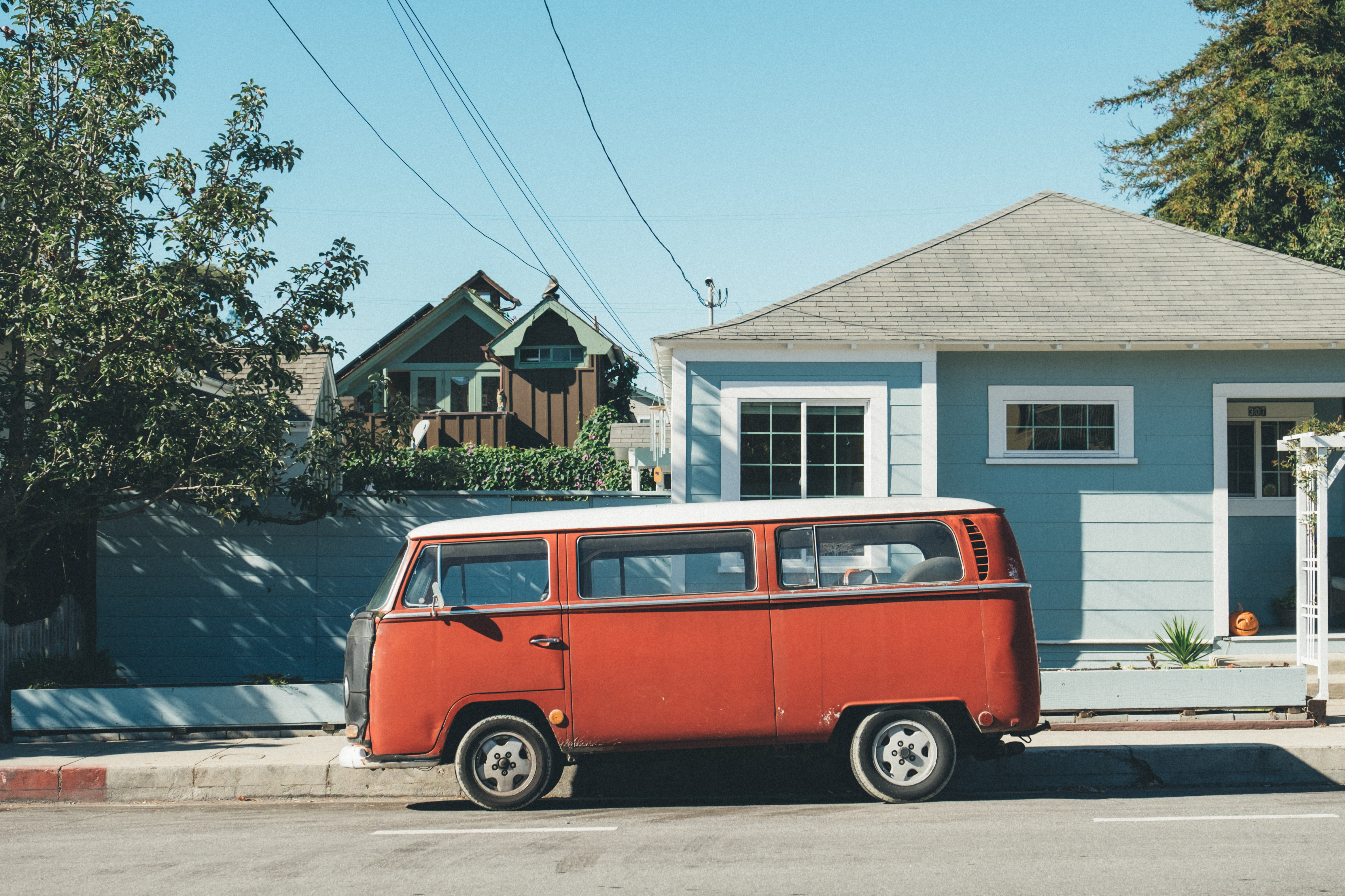 Red Volkswagen van parked on a street in front of houses HD Wallpaper