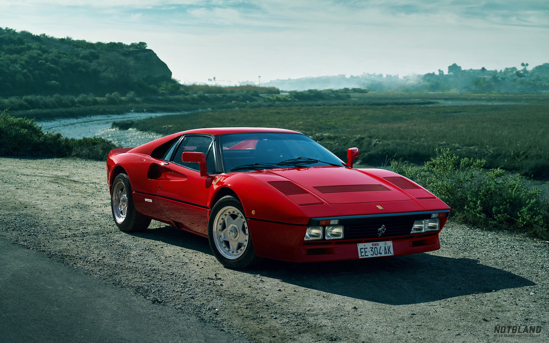 Red Ferrari 288 GTO on a dirt road near a marsh HD Wallpaper