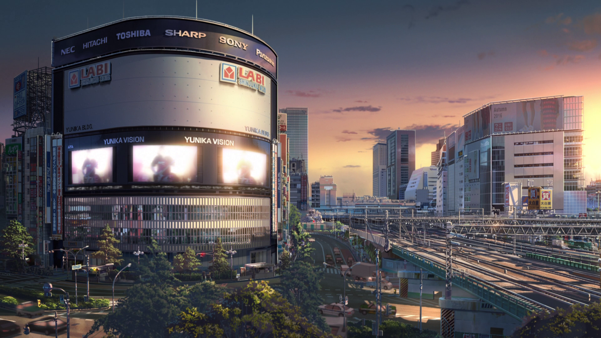 Cityscape with YUNIKA VISION billboards and train tracks HD Wallpaper