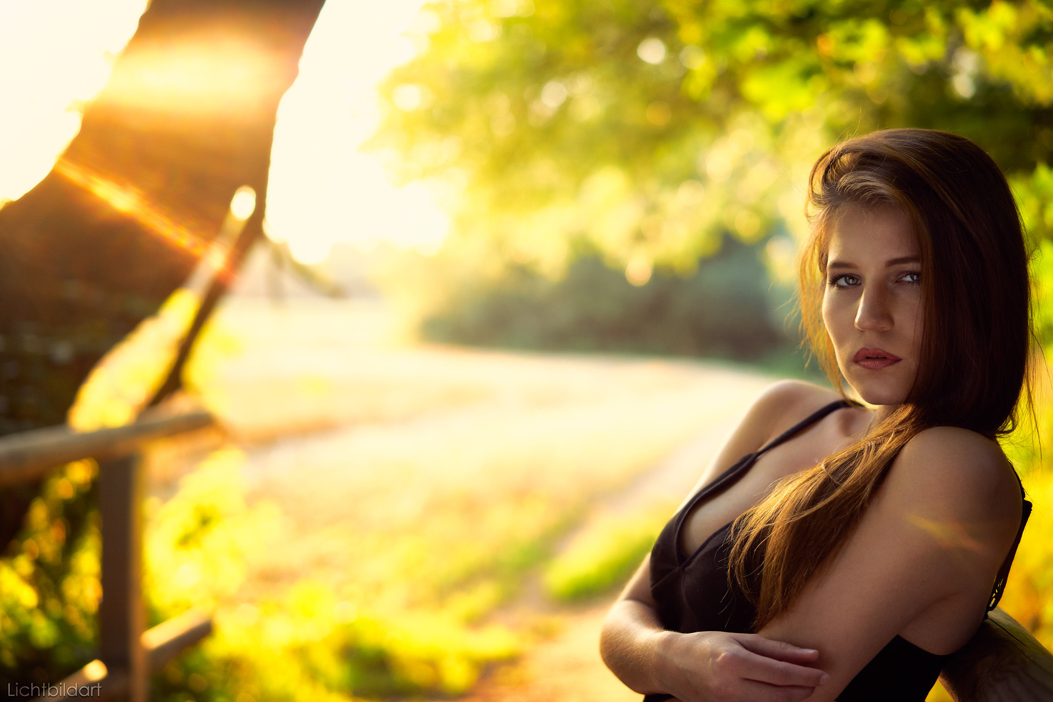 Woman in black dress in sunlight outdoors HD Wallpaper